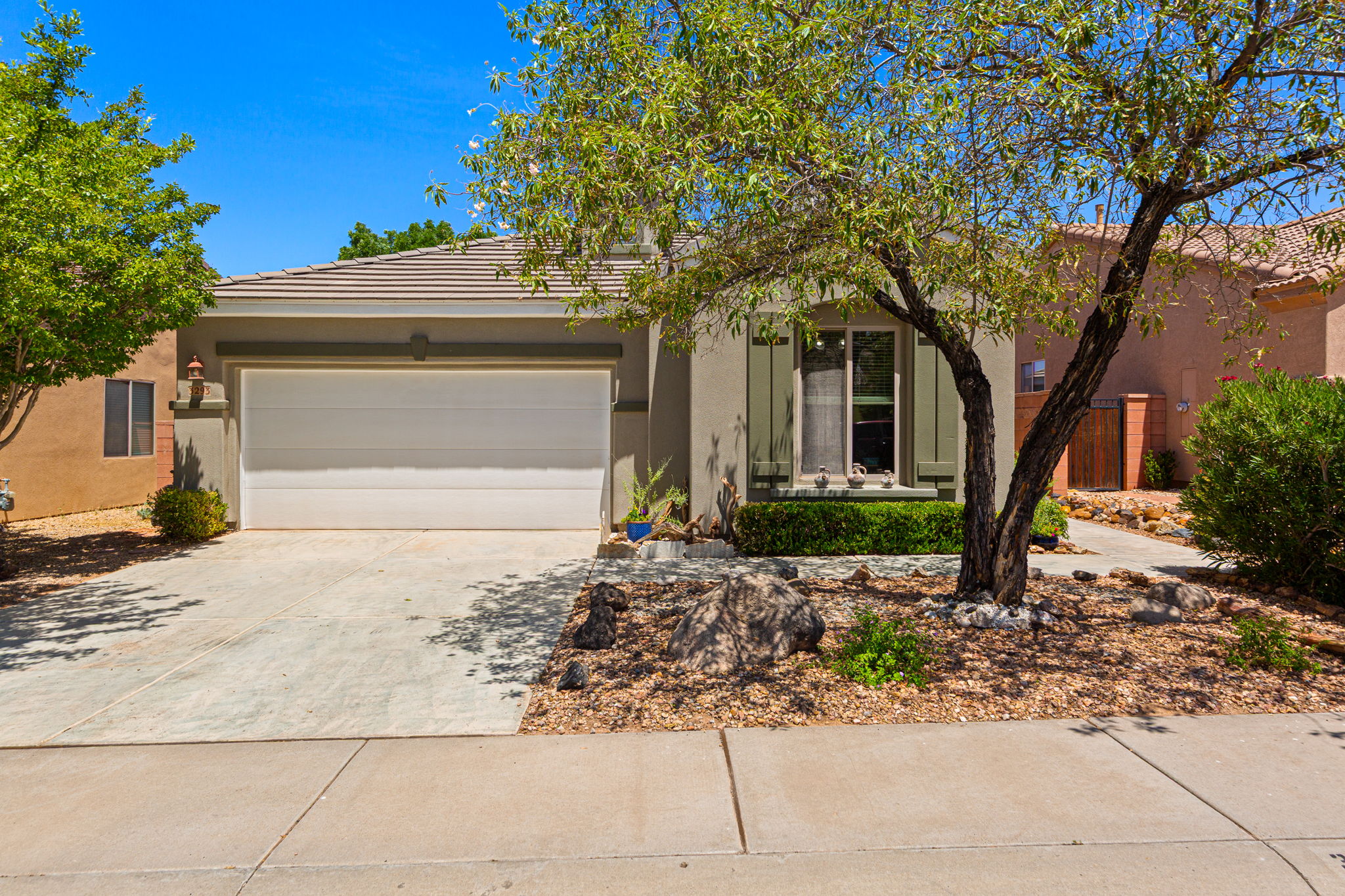 Single-story residence featuring a tile roof, an integrated garage with a white door, and a concrete driveway