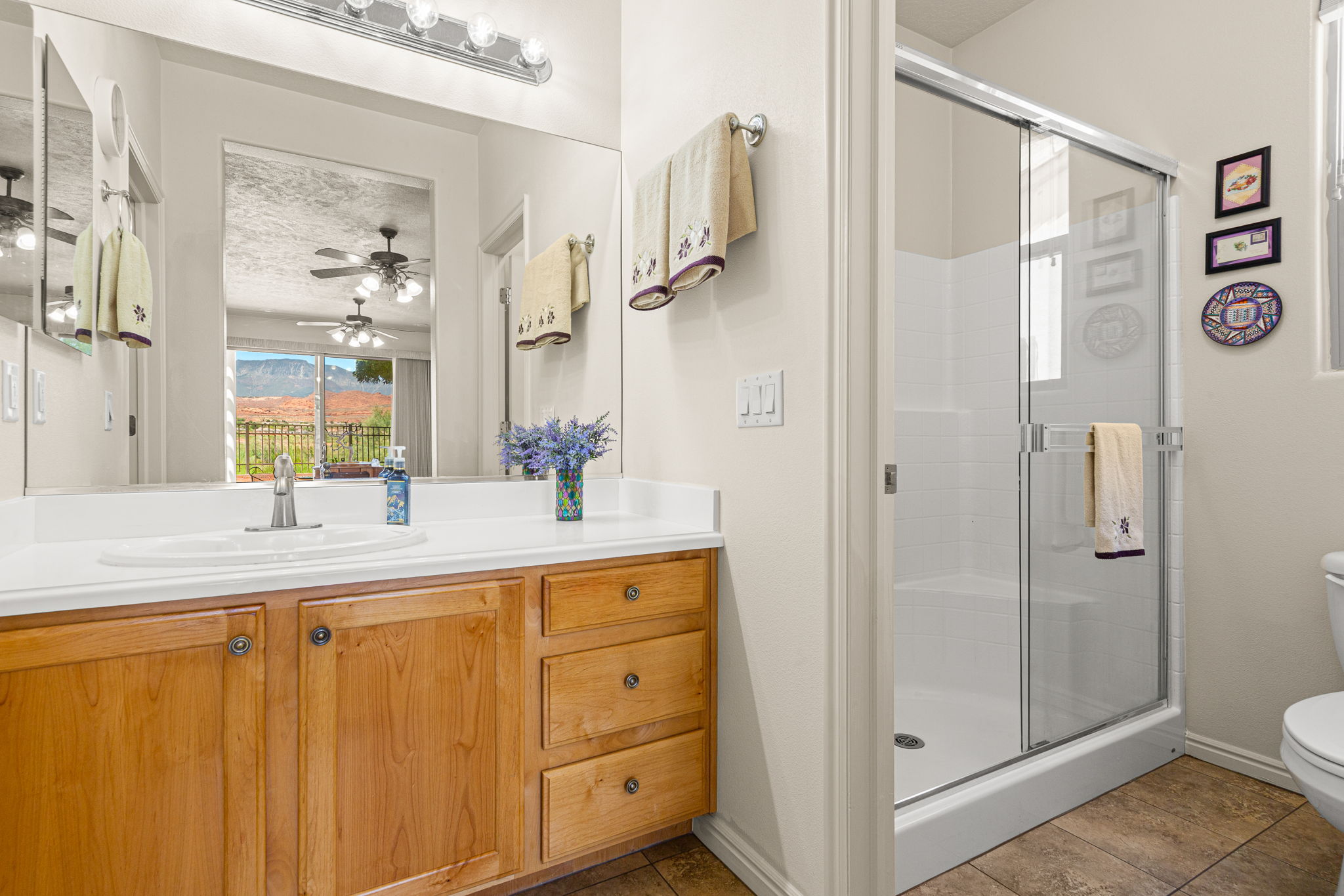 Bathroom featuring a wood-finish vanity with an integrated sink and a white countertop