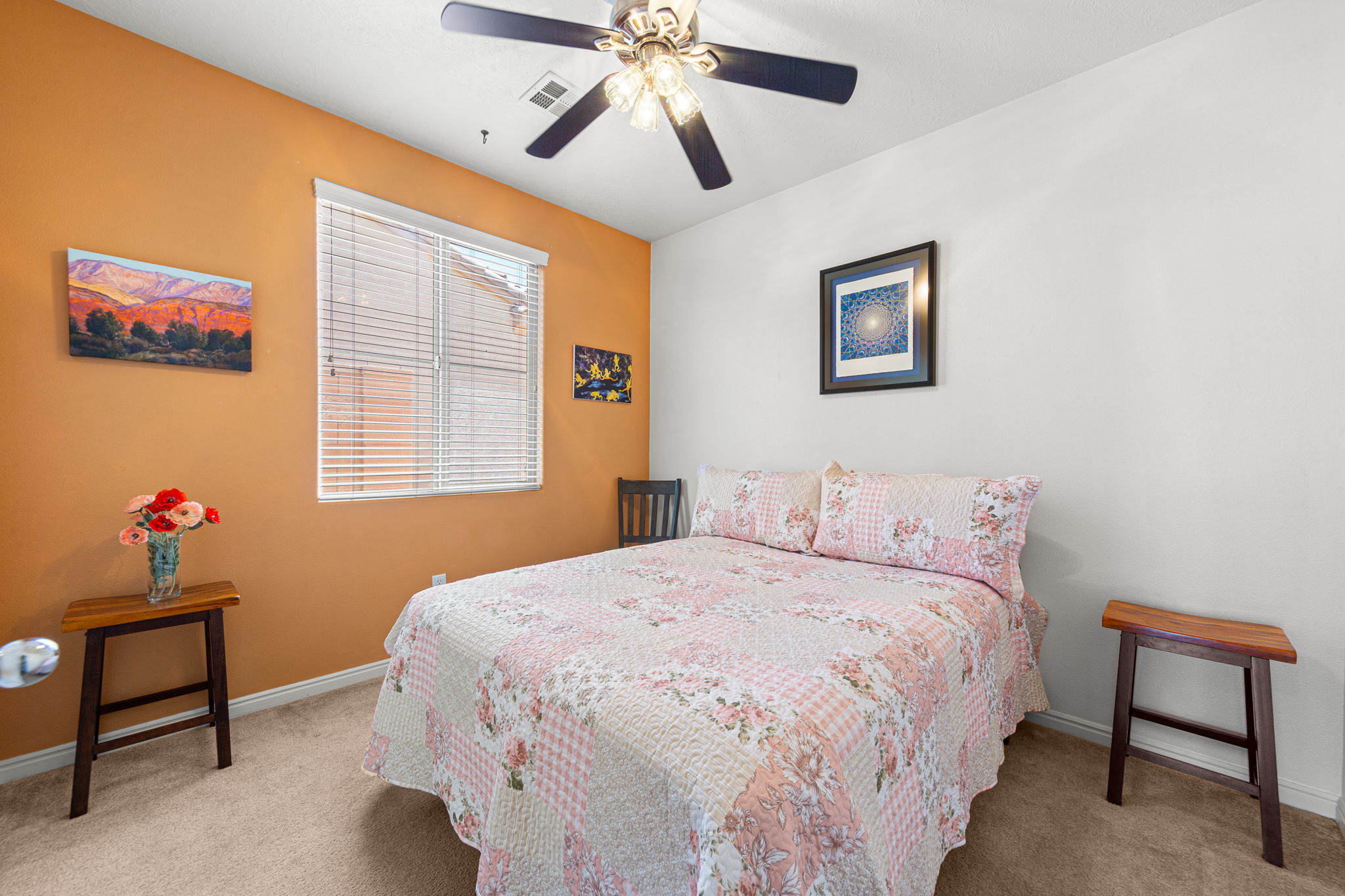 Carpeted room featuring a ceiling fan with integrated lighting, a window with horizontal blinds, and a two-tone wall finish
