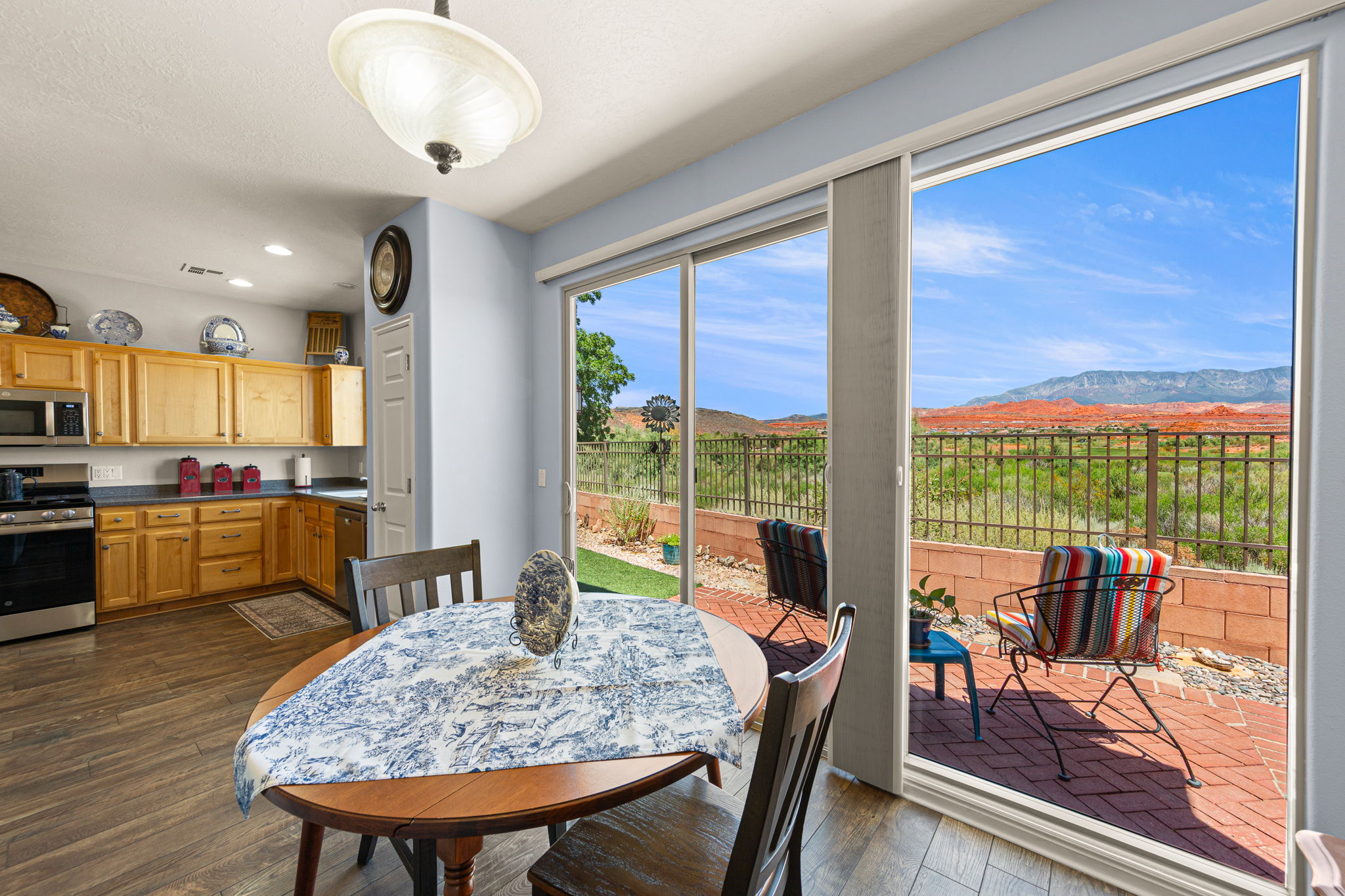Kitchen and dining area featuring wood-finish flooring, light wood cabinetry, and stainless steel appliances