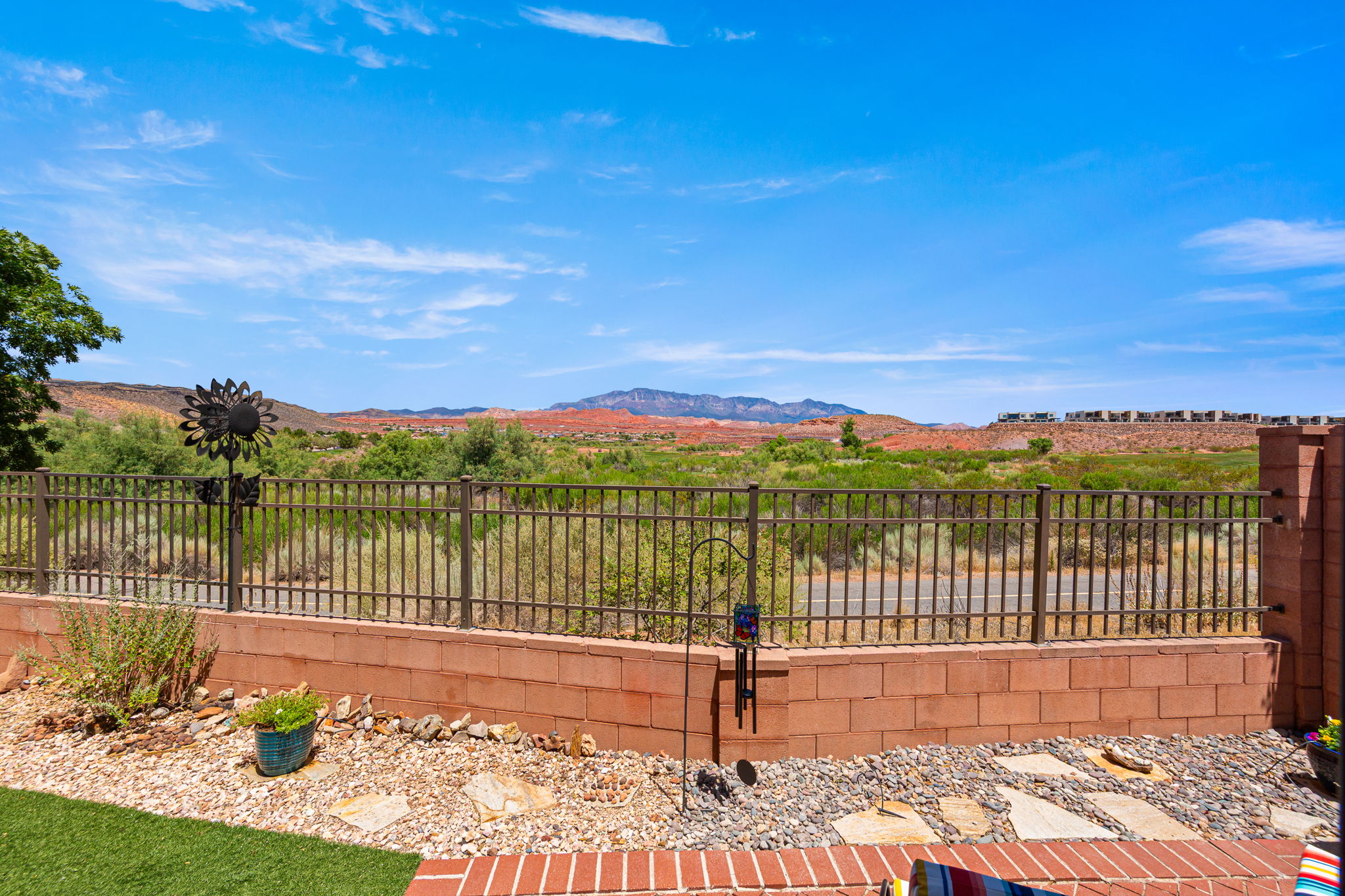 Expansive outdoor area featuring a combination of artificial turf, decorative gravel, and natural stone pavers