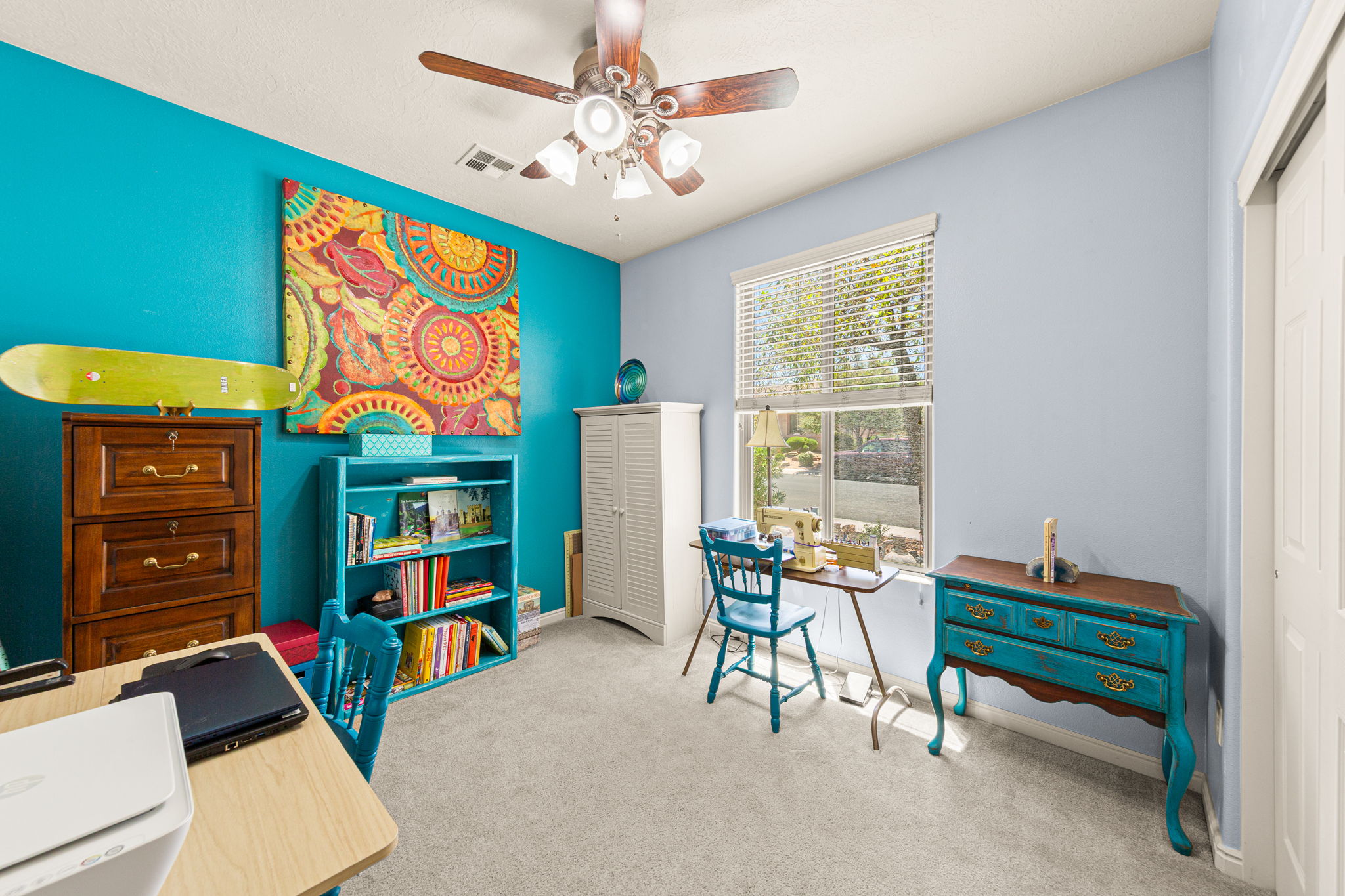 Interior room featuring light gray carpeting, a window with horizontal blinds, and a built-in ceiling fan with integrated lighting