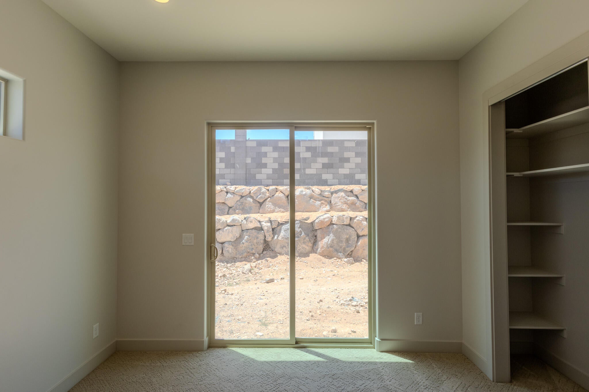 Sliding glass door leading to an outdoor space with rock landscaping