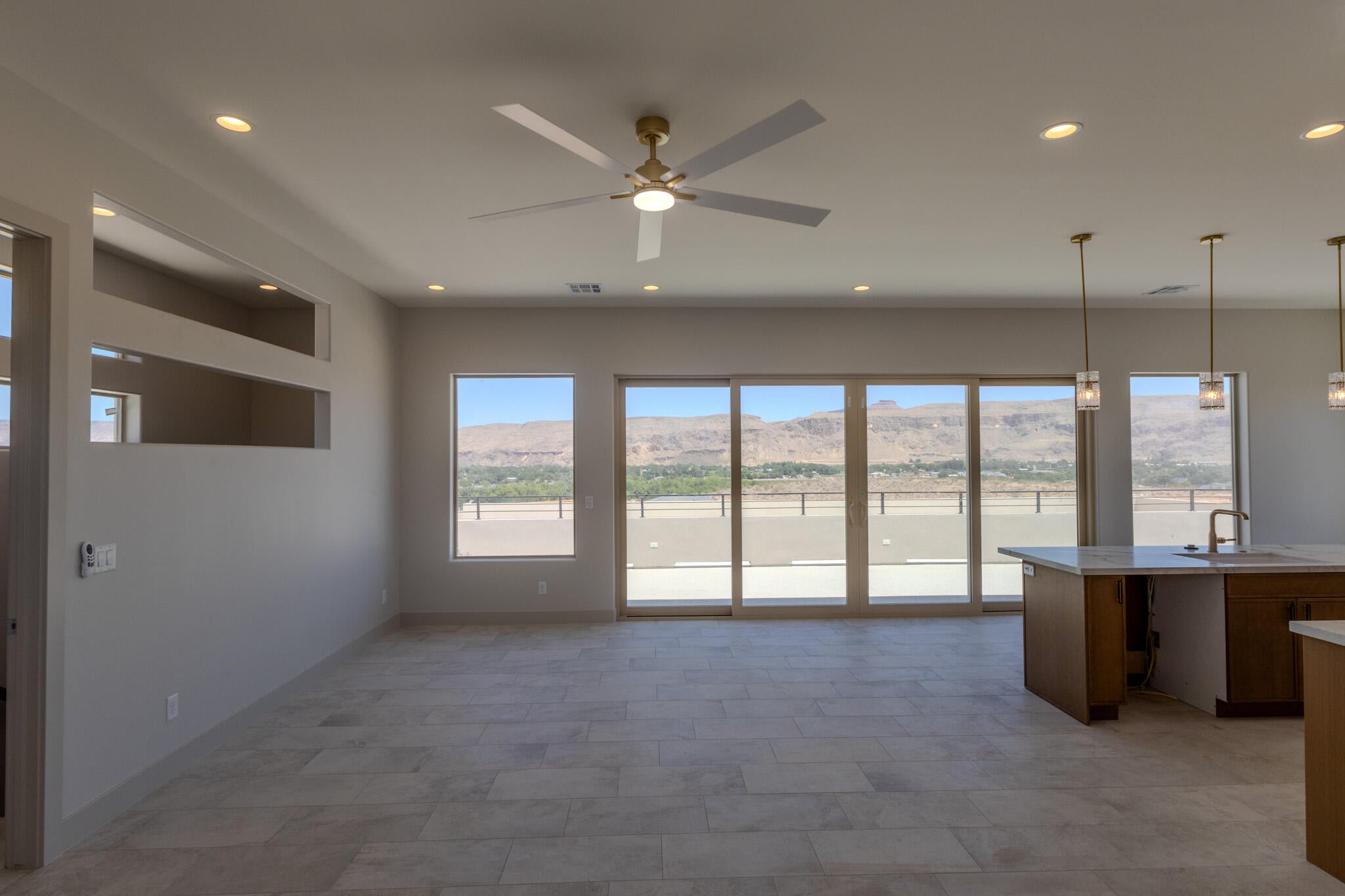Open-concept living space with expansive sliding glass doors offering a desert mountain backdrop