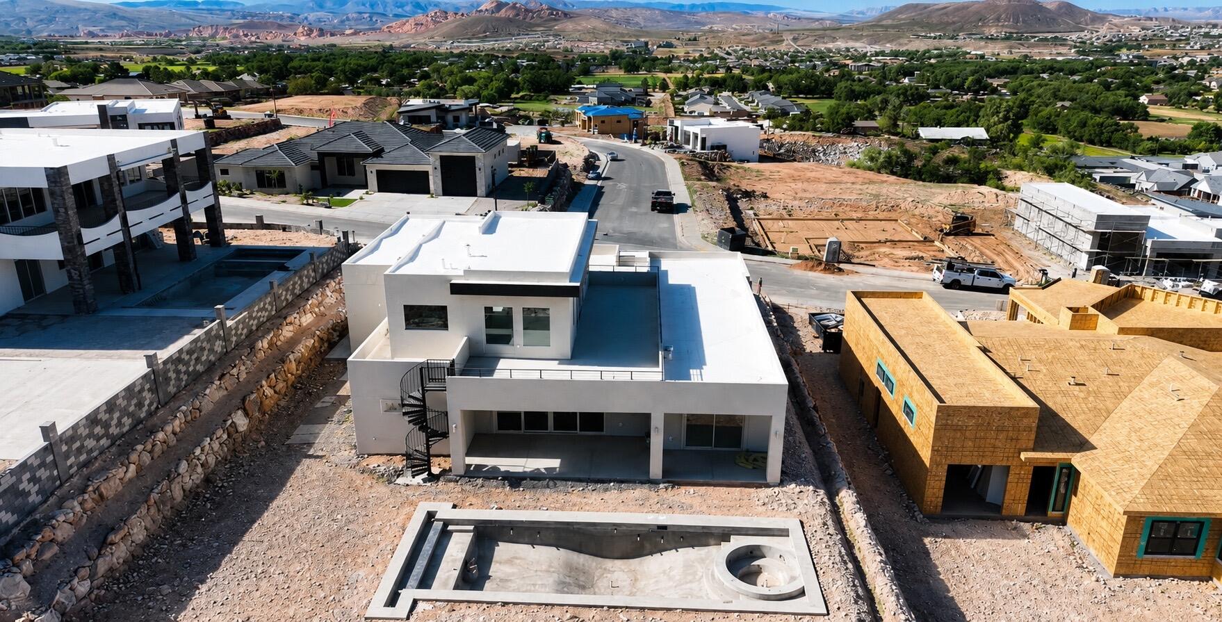 Modern contemporary residence featuring a flat roofline, integrated two-car garage, and a spiral staircase to an upper-level deck