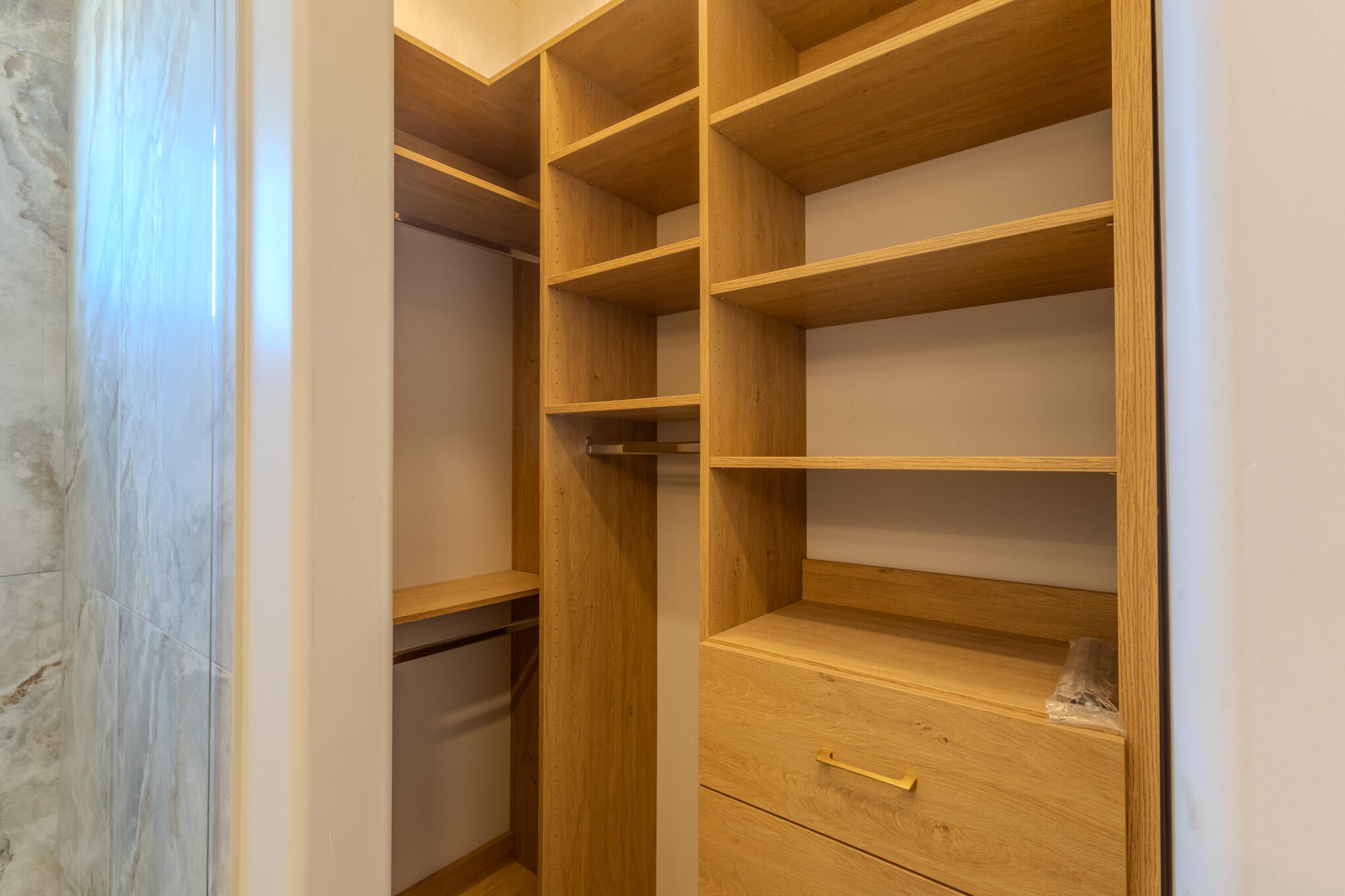 Custom closet system featuring wood-finish shelving and built-in drawers