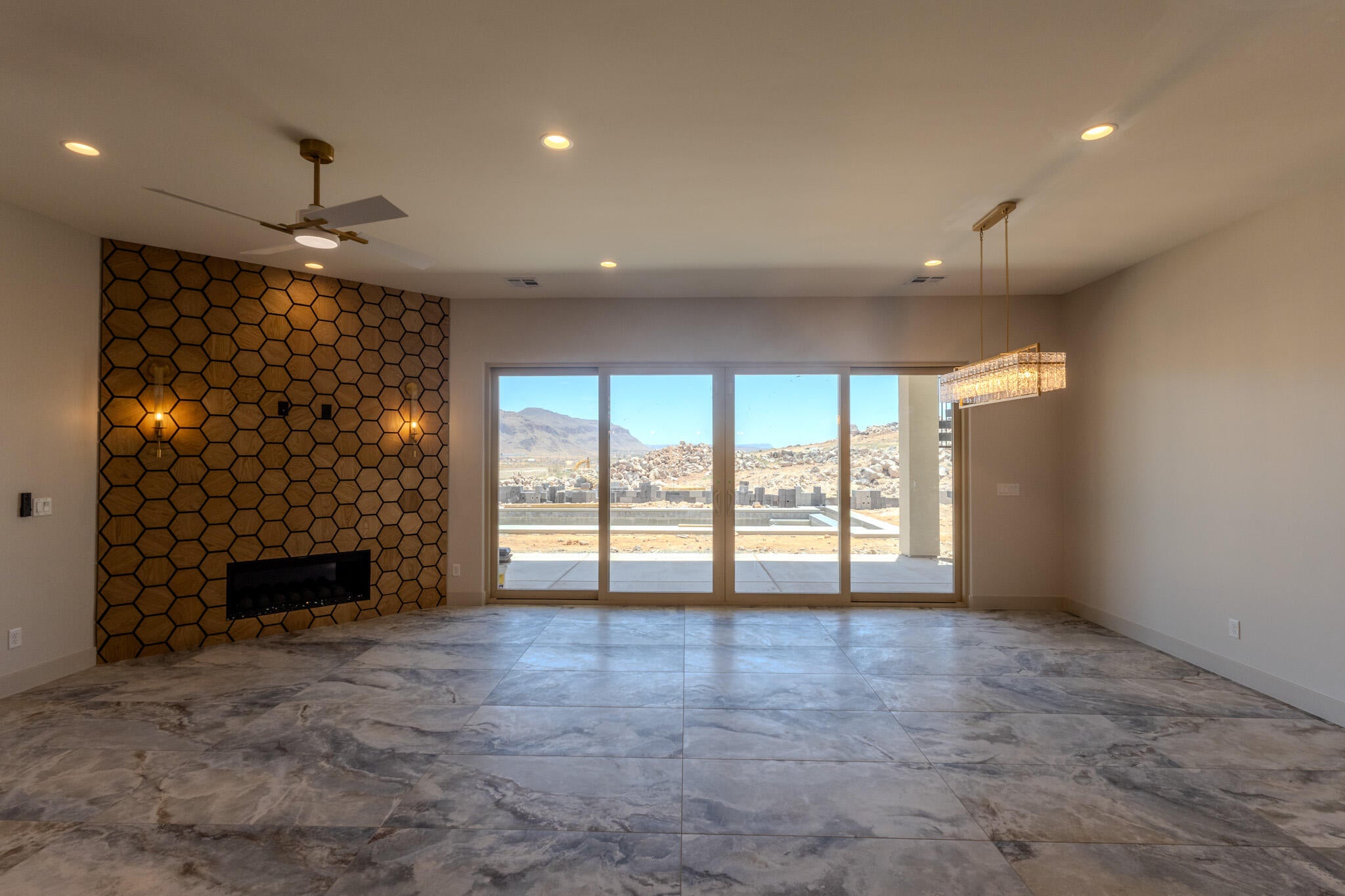 Spacious room featuring large format tile flooring and a hexagonal accent wall with an electric fireplace