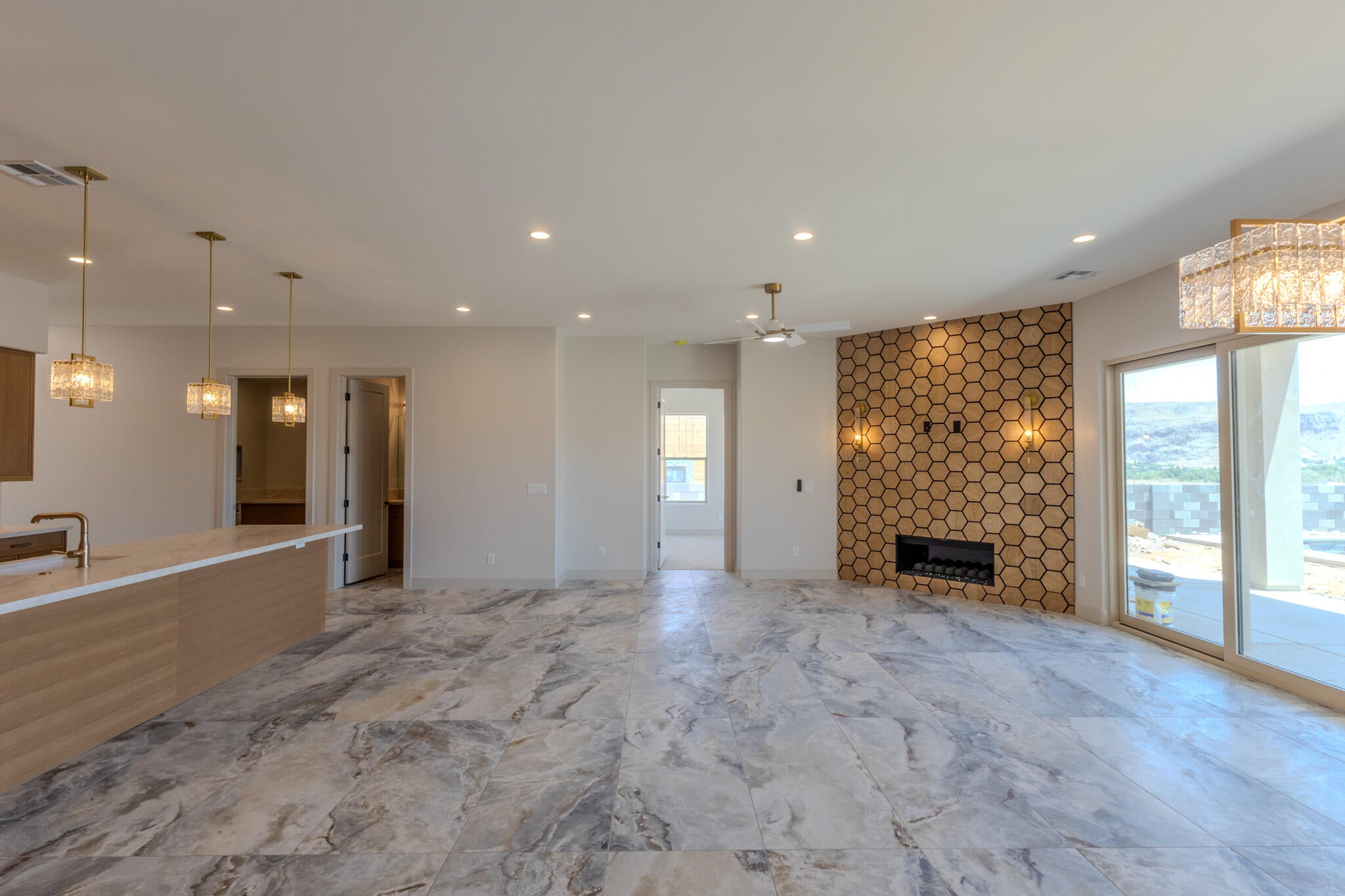 Open-concept living area featuring large format tile flooring, a fireplace with a hexagonal surround, and recessed lighting