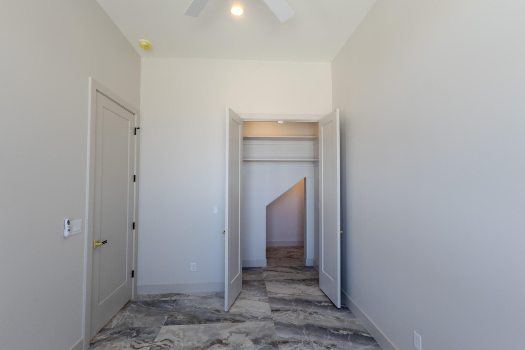 Interior room with light gray walls and dark veined tile flooring