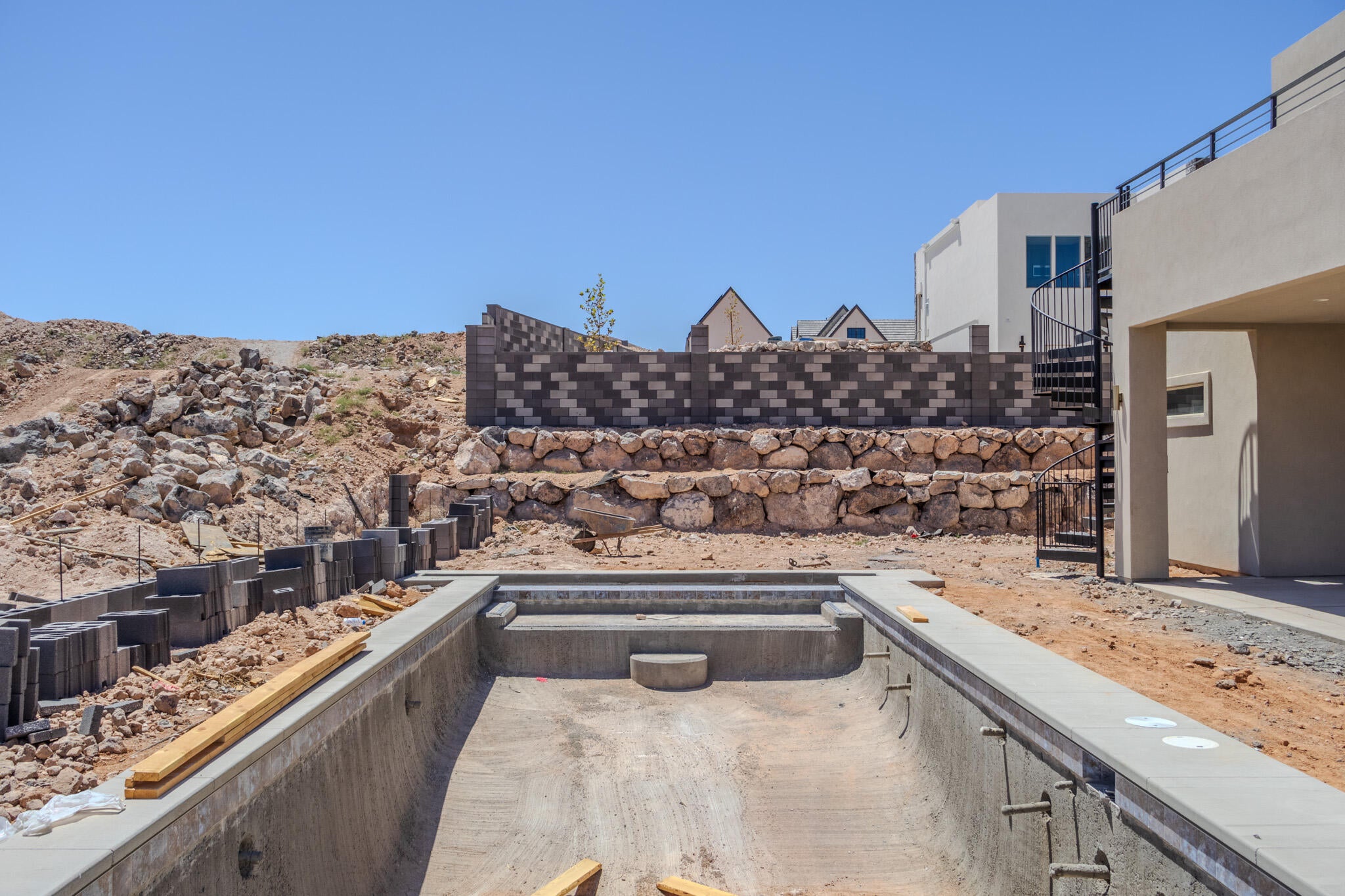 Concrete shell for a future swimming pool with integrated steps and a surrounding concrete coping