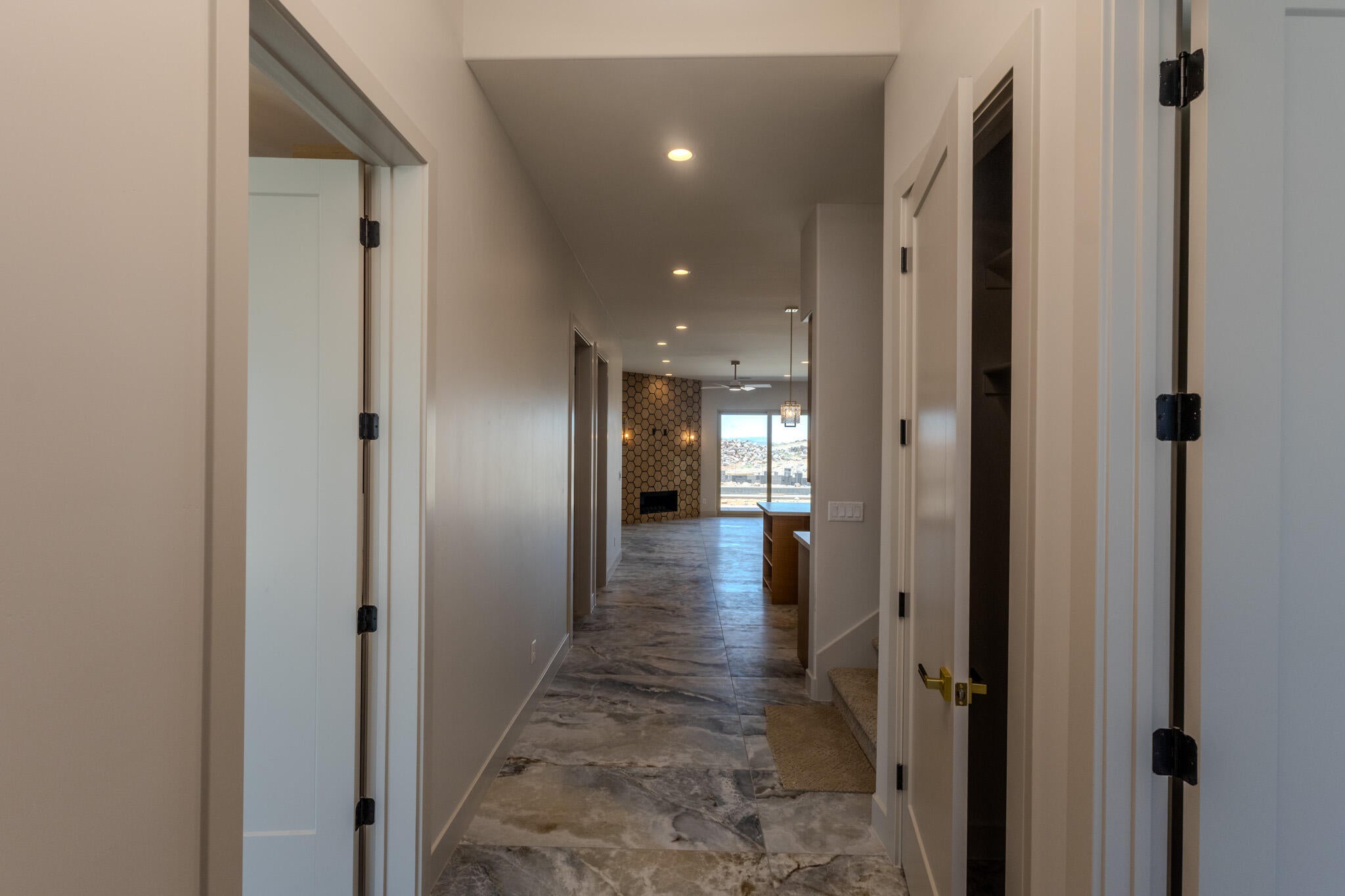 Hallway featuring light-toned walls, recessed lighting, and stone-finish flooring