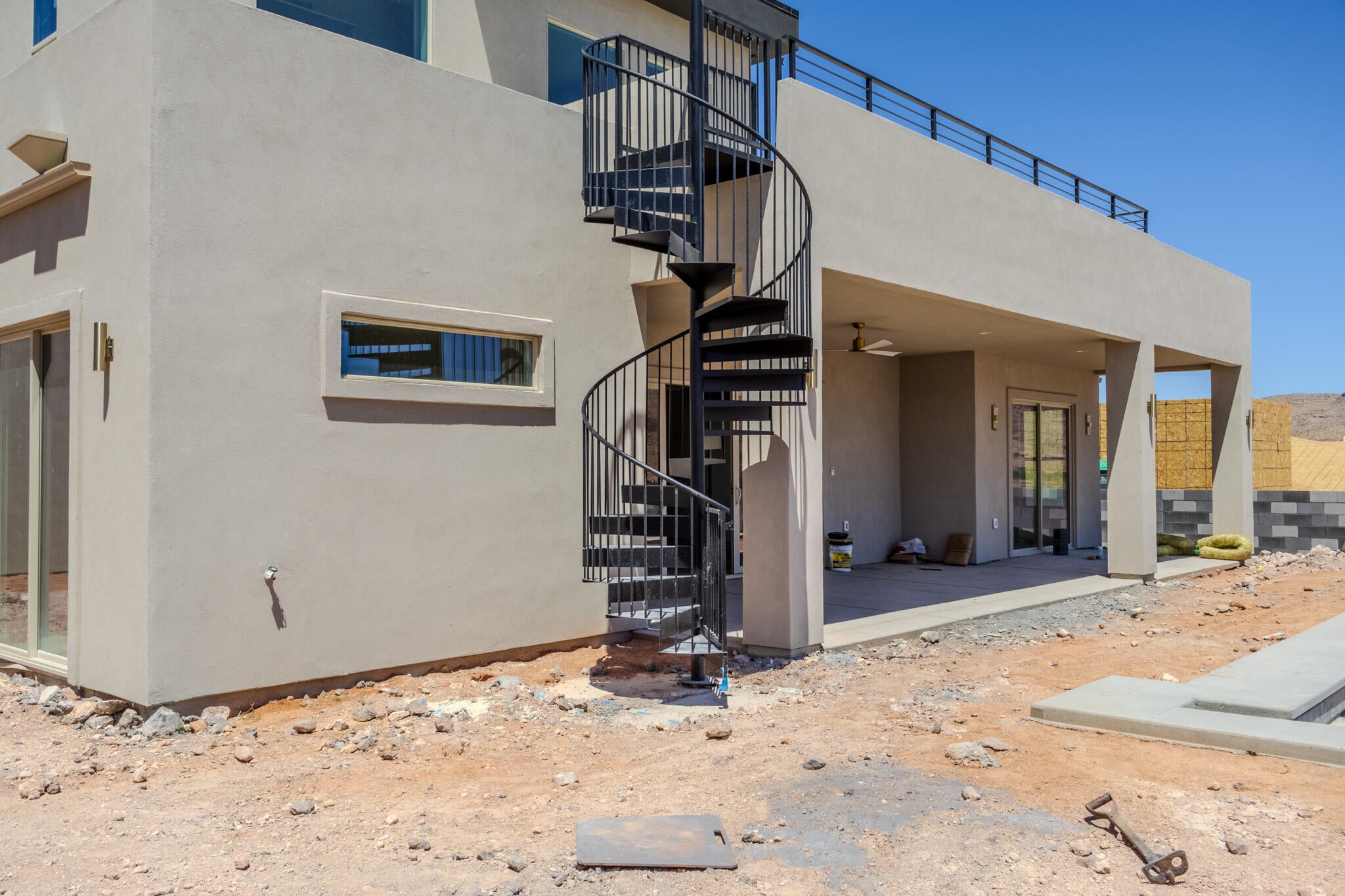 Exterior spiral staircase leading to an upper-level balcony