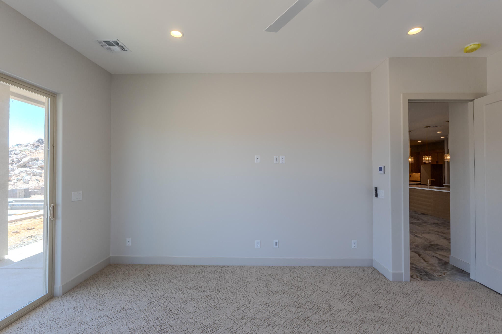 Spacious room featuring neutral carpeting, recessed lighting, and a ceiling fan