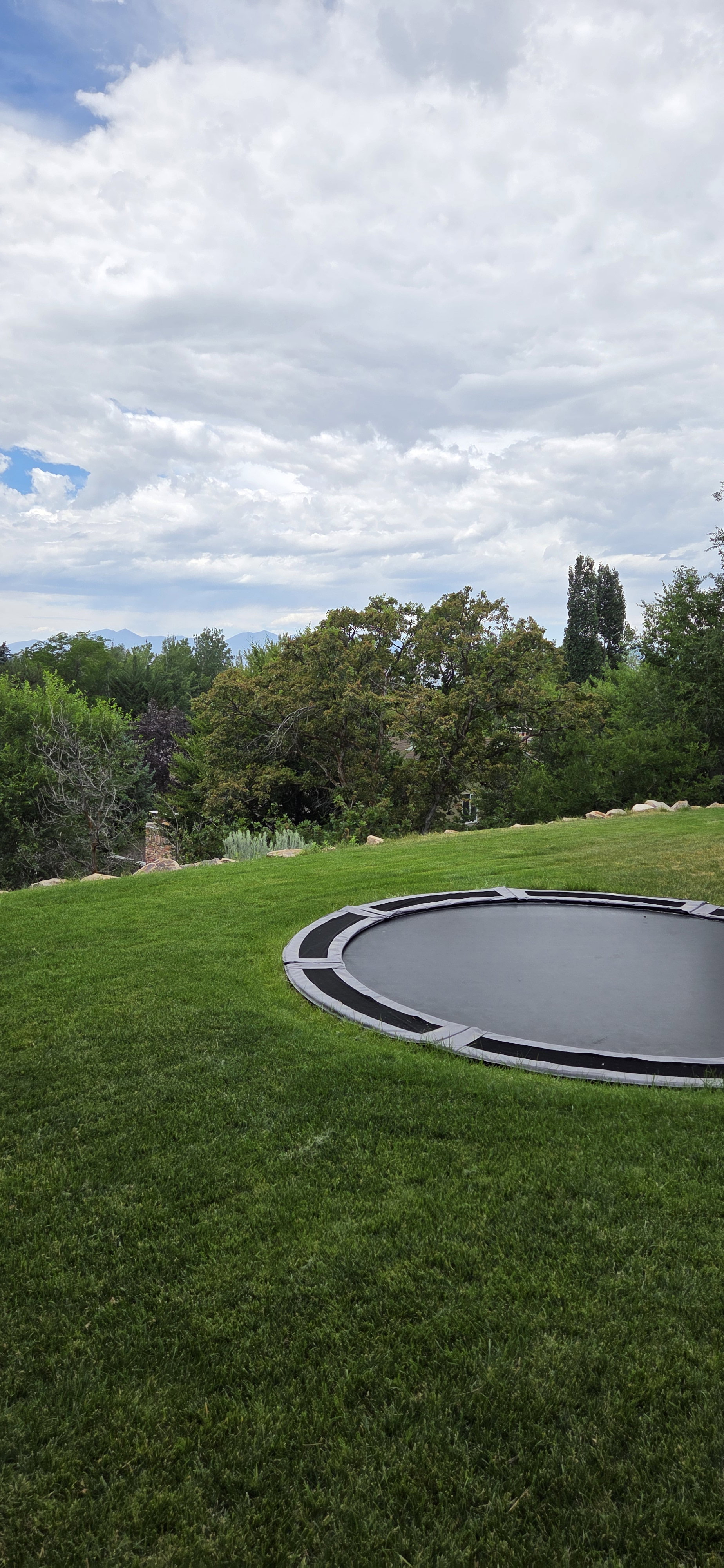 Expansive lawn featuring an in-ground trampoline