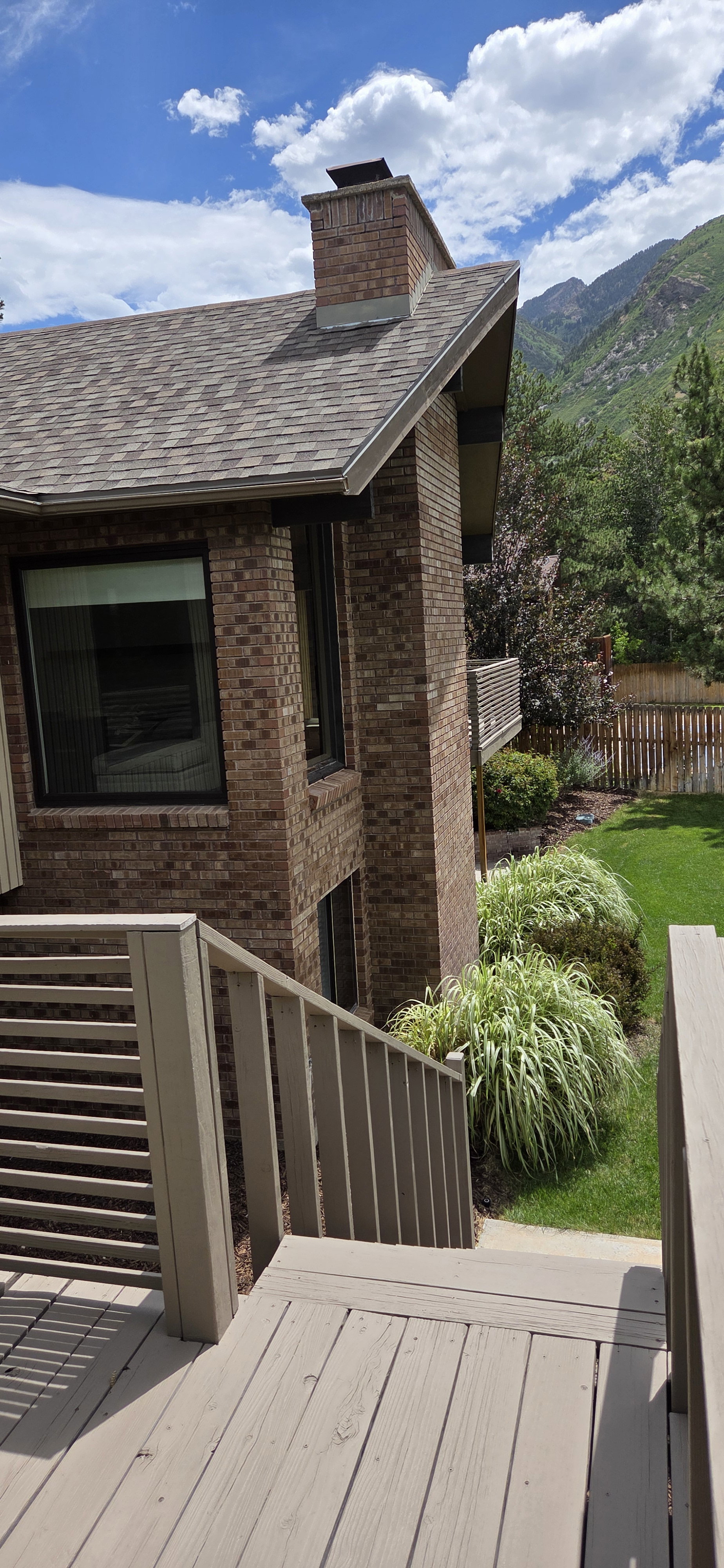 Multi-level deck with slatted railings and stairs descending to a landscaped yard