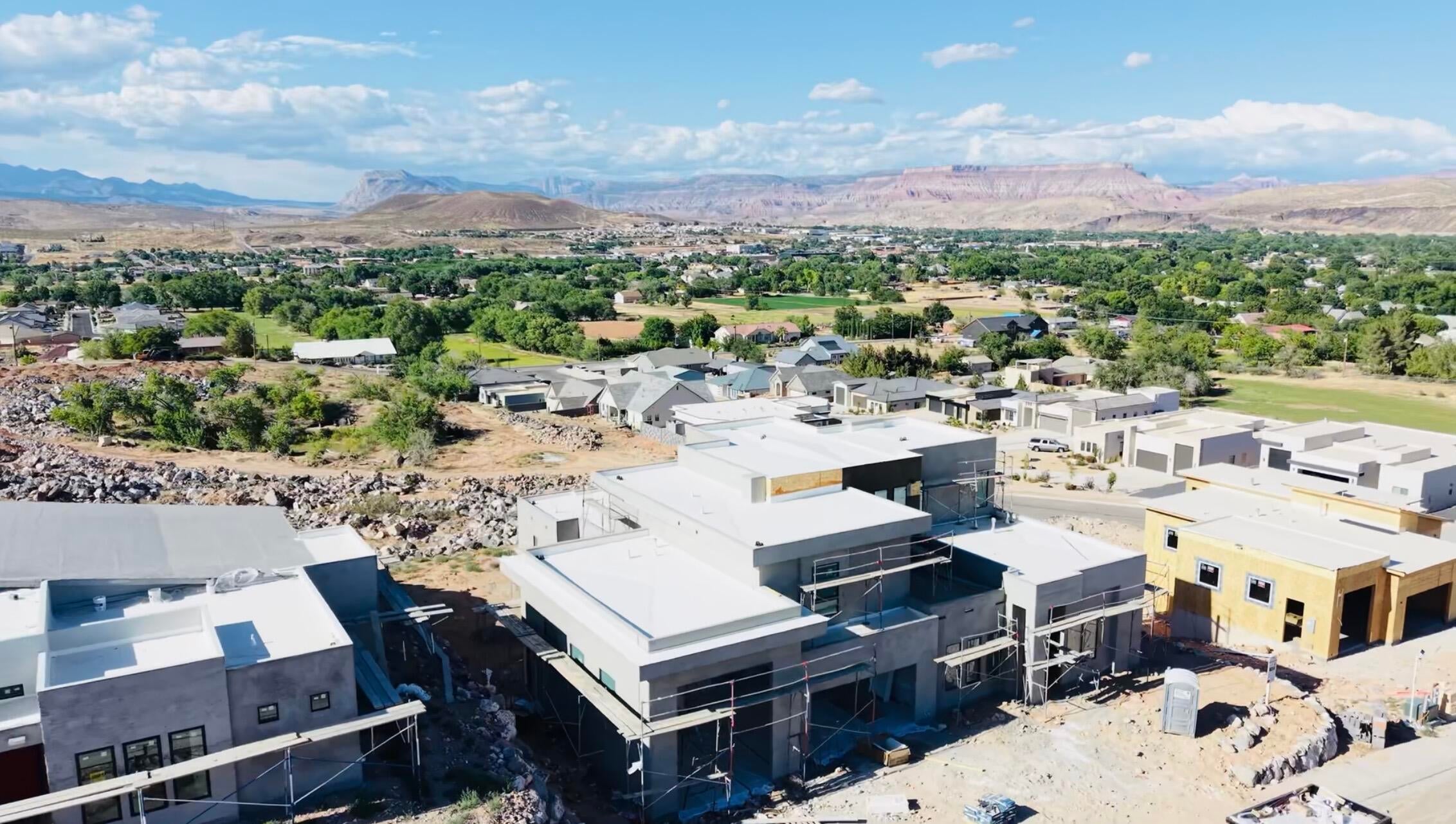 New construction properties under development, featuring modern architecture with flat roofs and stucco exteriors