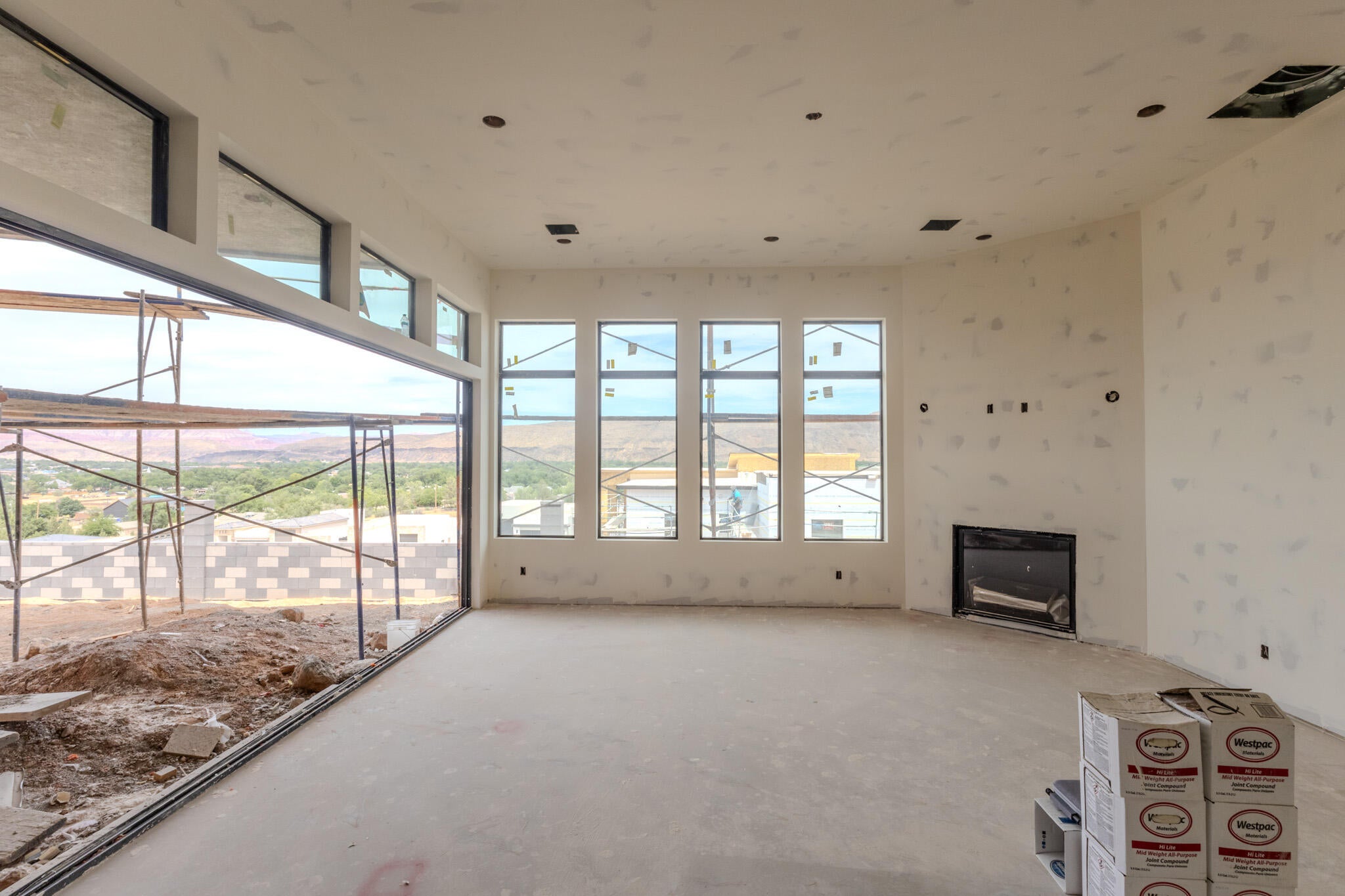 Expansive interior space featuring multiple large windows and a built-in fireplace