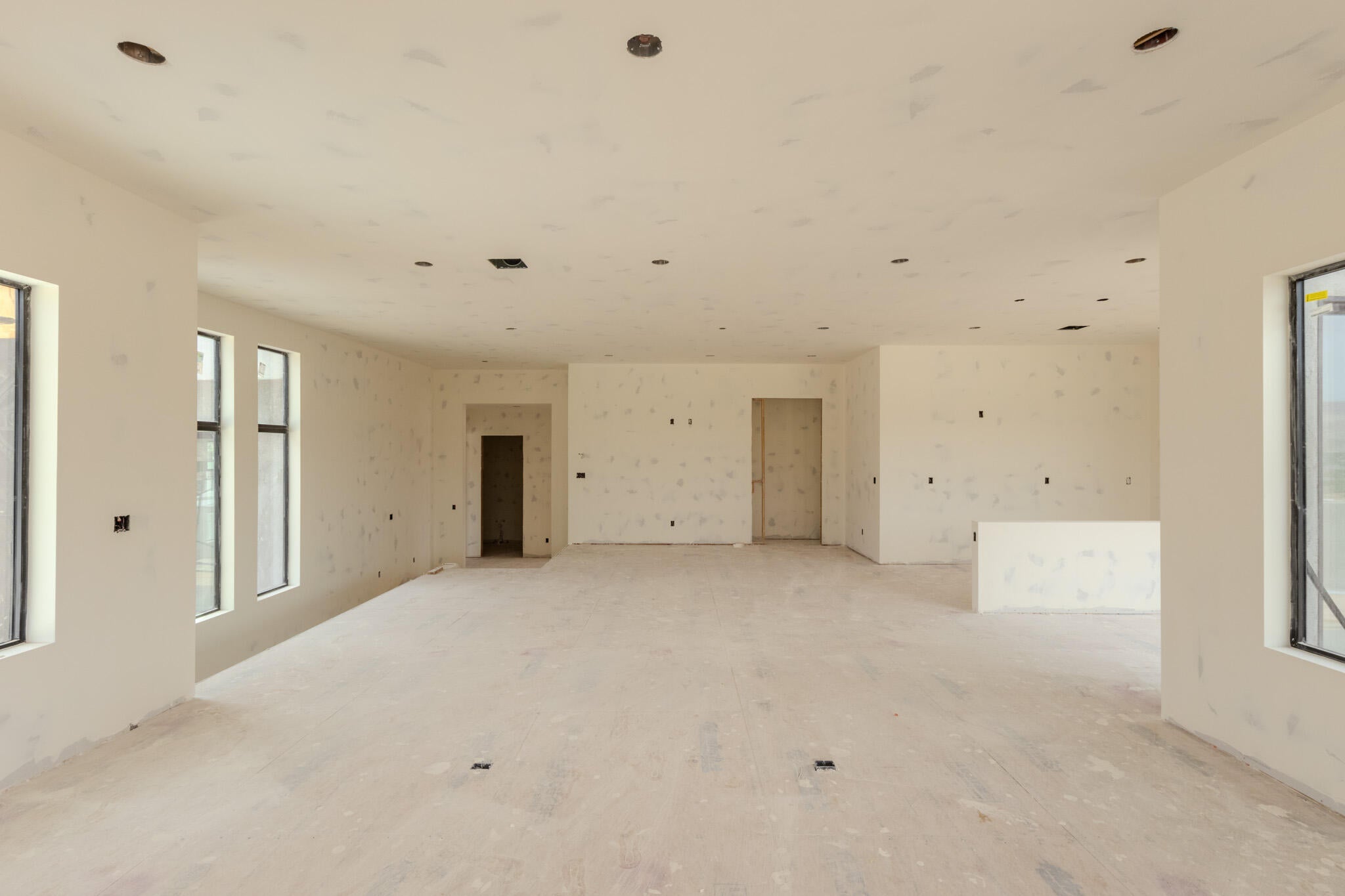 Spacious interior featuring multiple large windows, recessed ceiling lighting, and a neutral wall finish