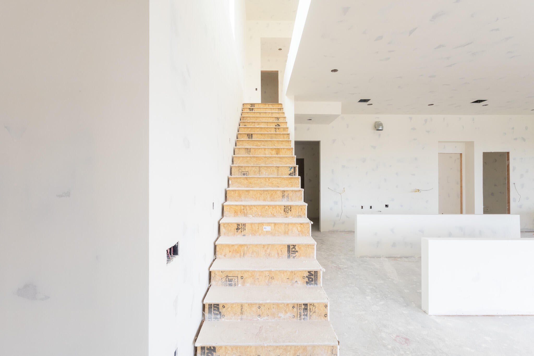 Unfinished interior space with exposed wooden stair treads and risers