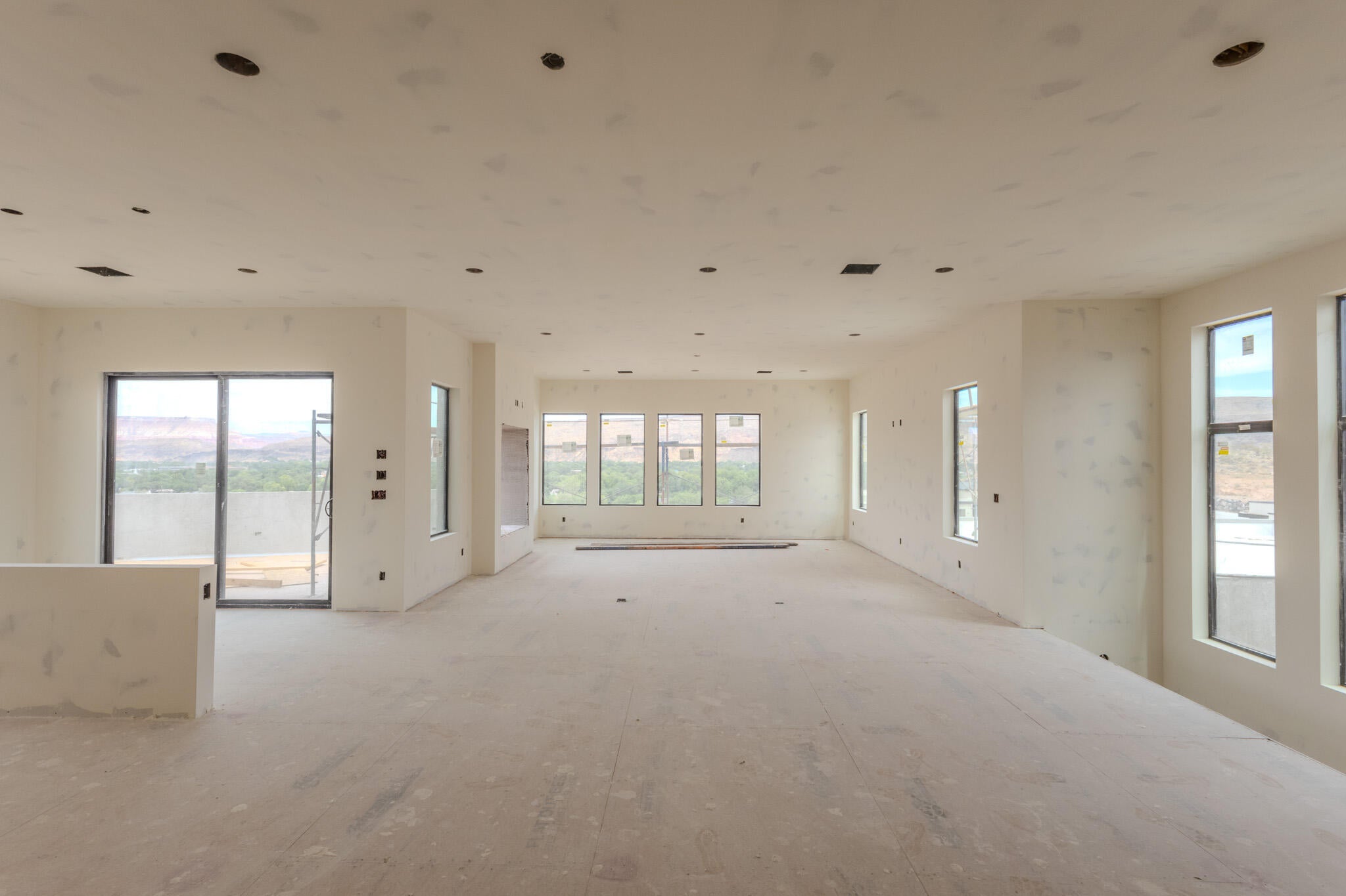 Expansive open-concept space featuring numerous windows and a sliding glass door