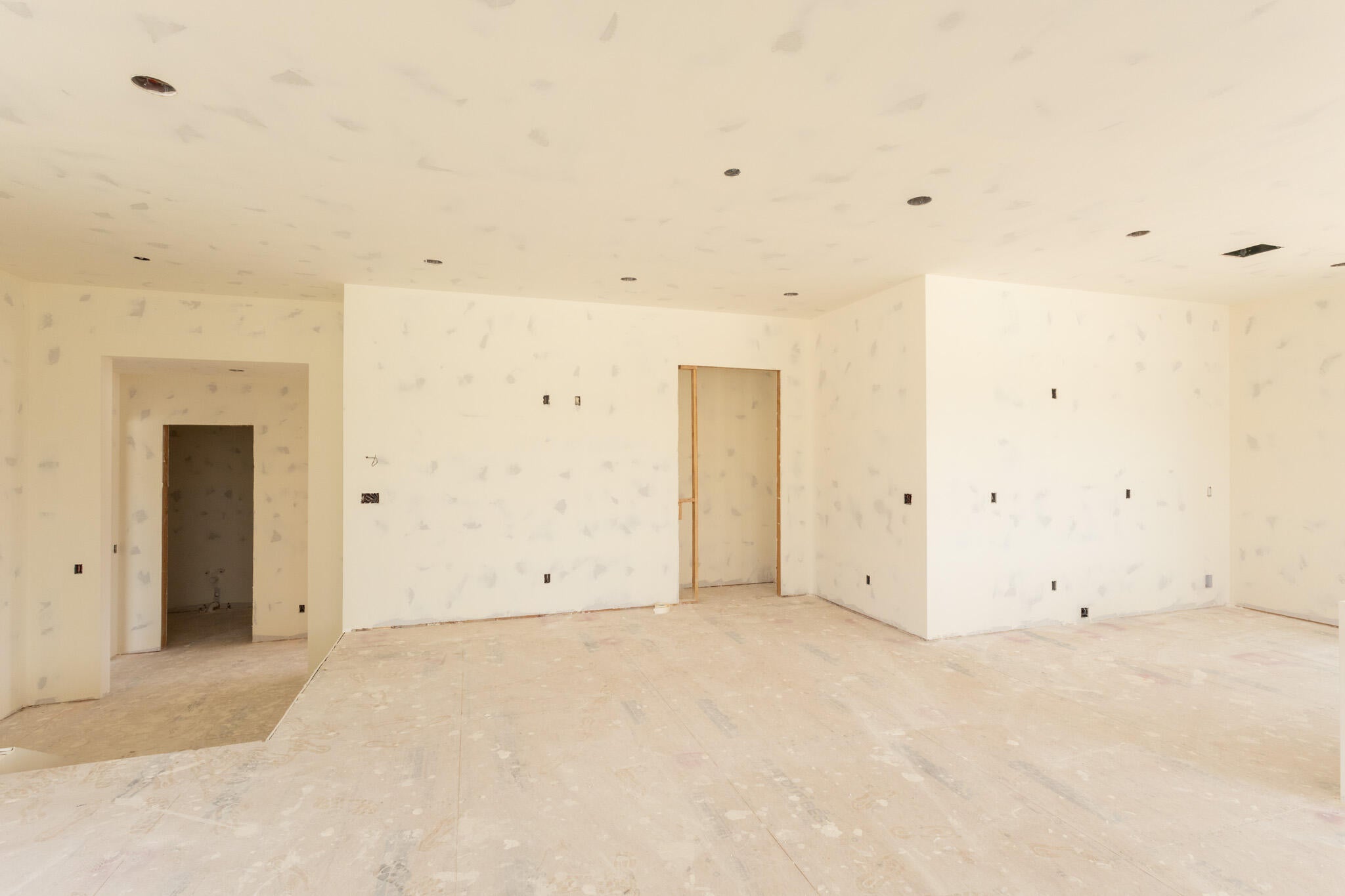 Spacious room featuring multiple recessed lighting fixtures, smooth drywall finishes, and a neutral color palette