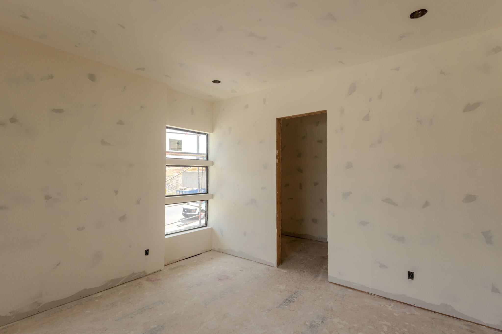 Room featuring three horizontal transom windows, an unfinished door frame, and recessed ceiling lighting