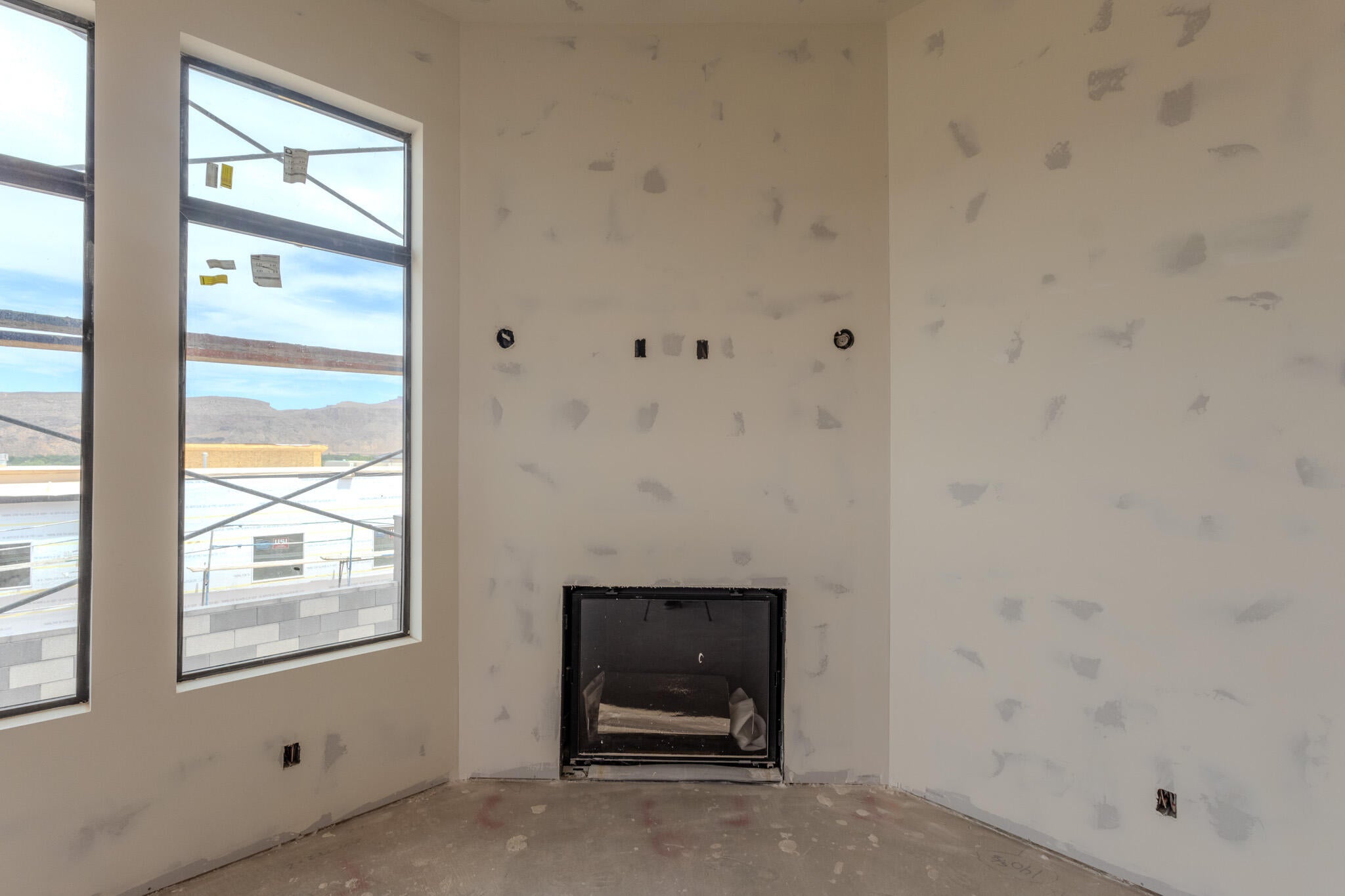 Room featuring a built-in fireplace, large windows, and an expansive wall space