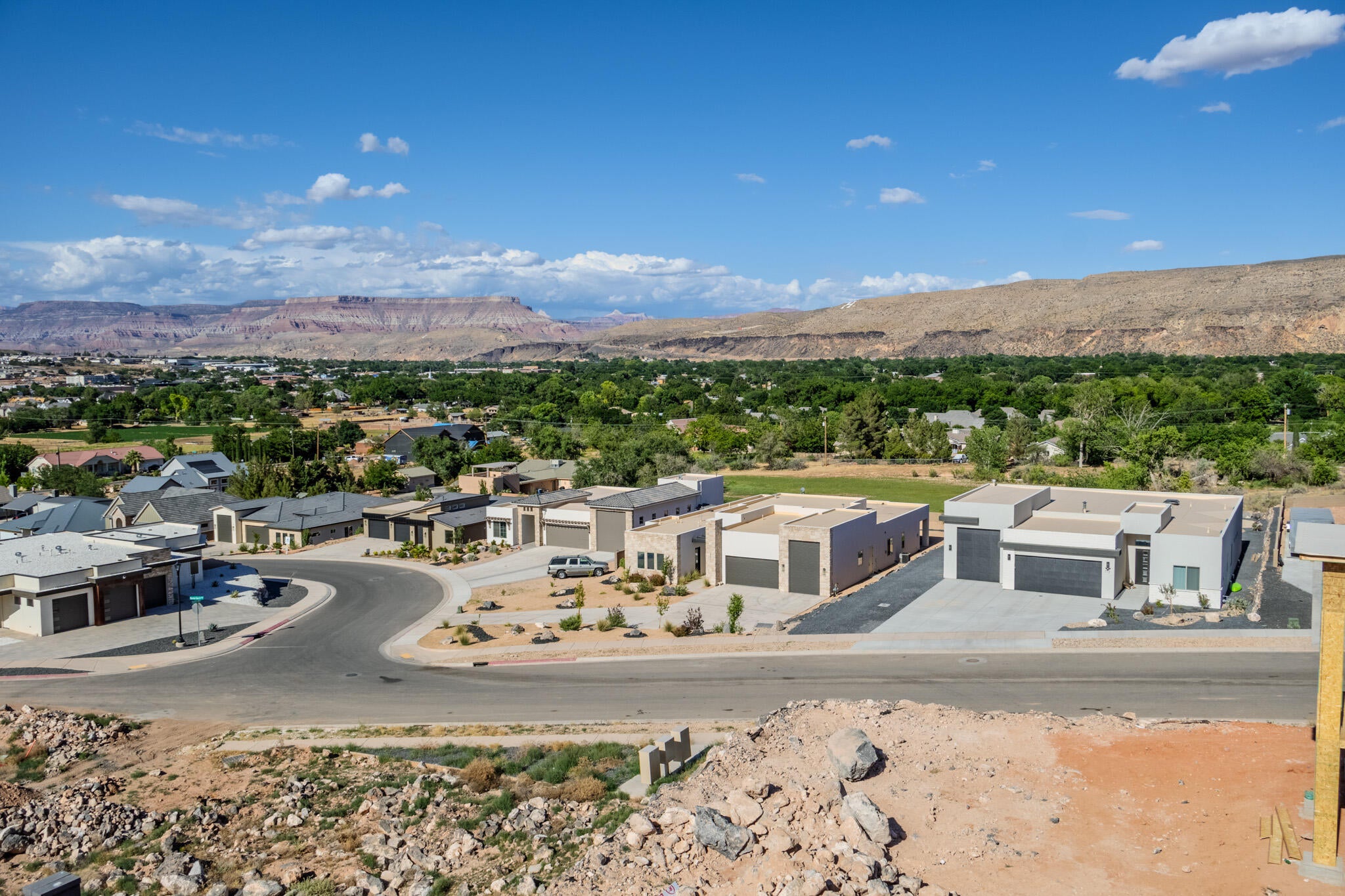 Modern residential streetscape featuring contemporary architecture, paved roads, and xeriscaped front yards