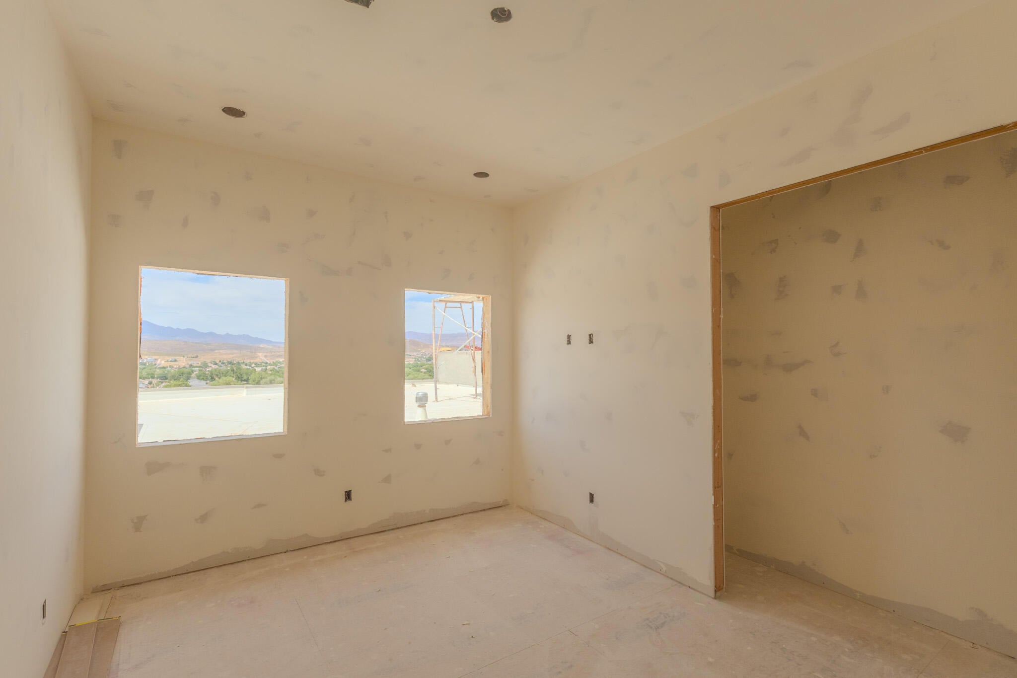 Interior room with two rectangular windows, recessed ceiling lighting, and a doorway