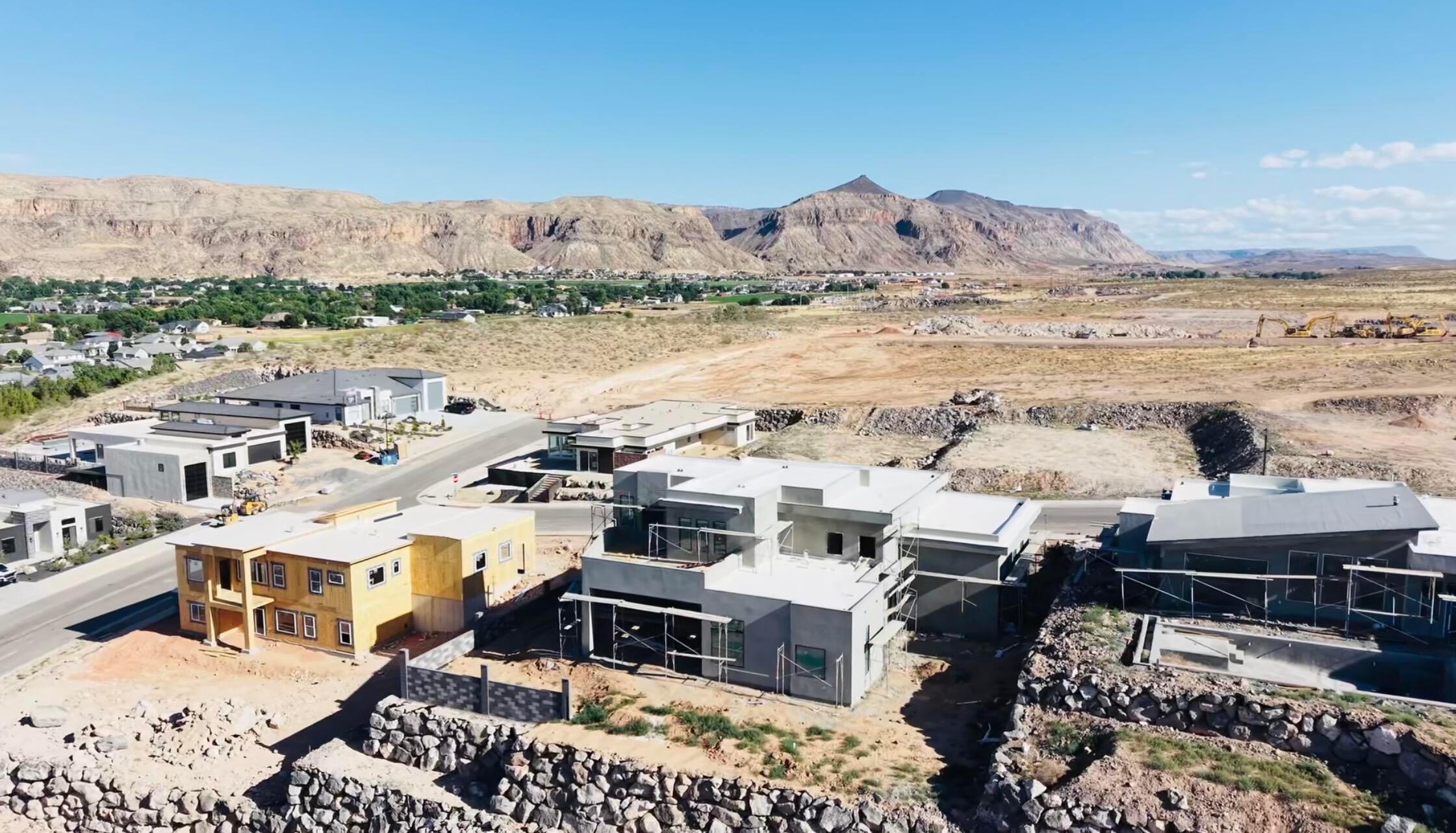 New construction home in framing stage, featuring a two-story design with prominent windows