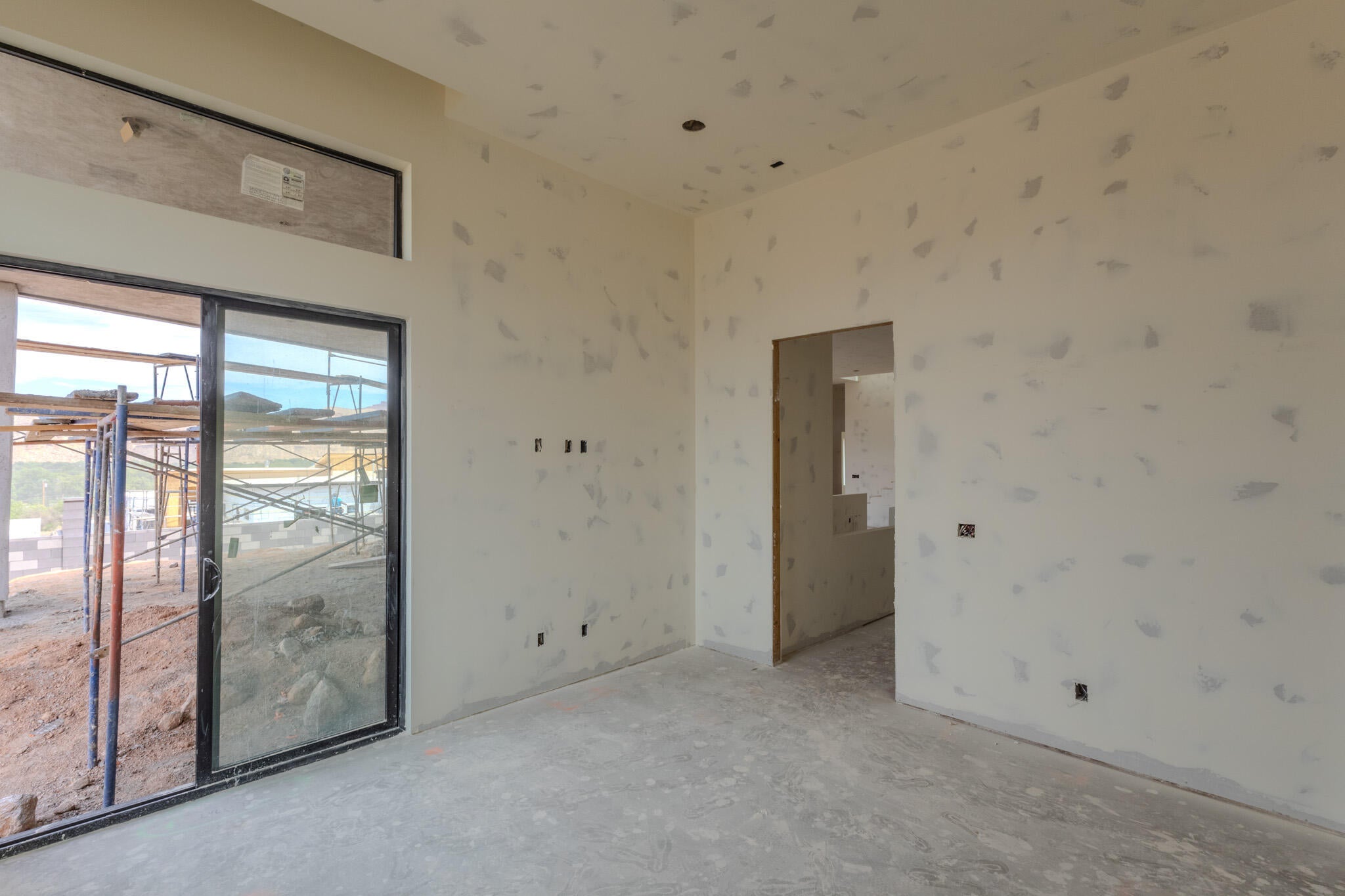Spacious interior room with concrete flooring, framed doorway, and recessed ceiling lighting