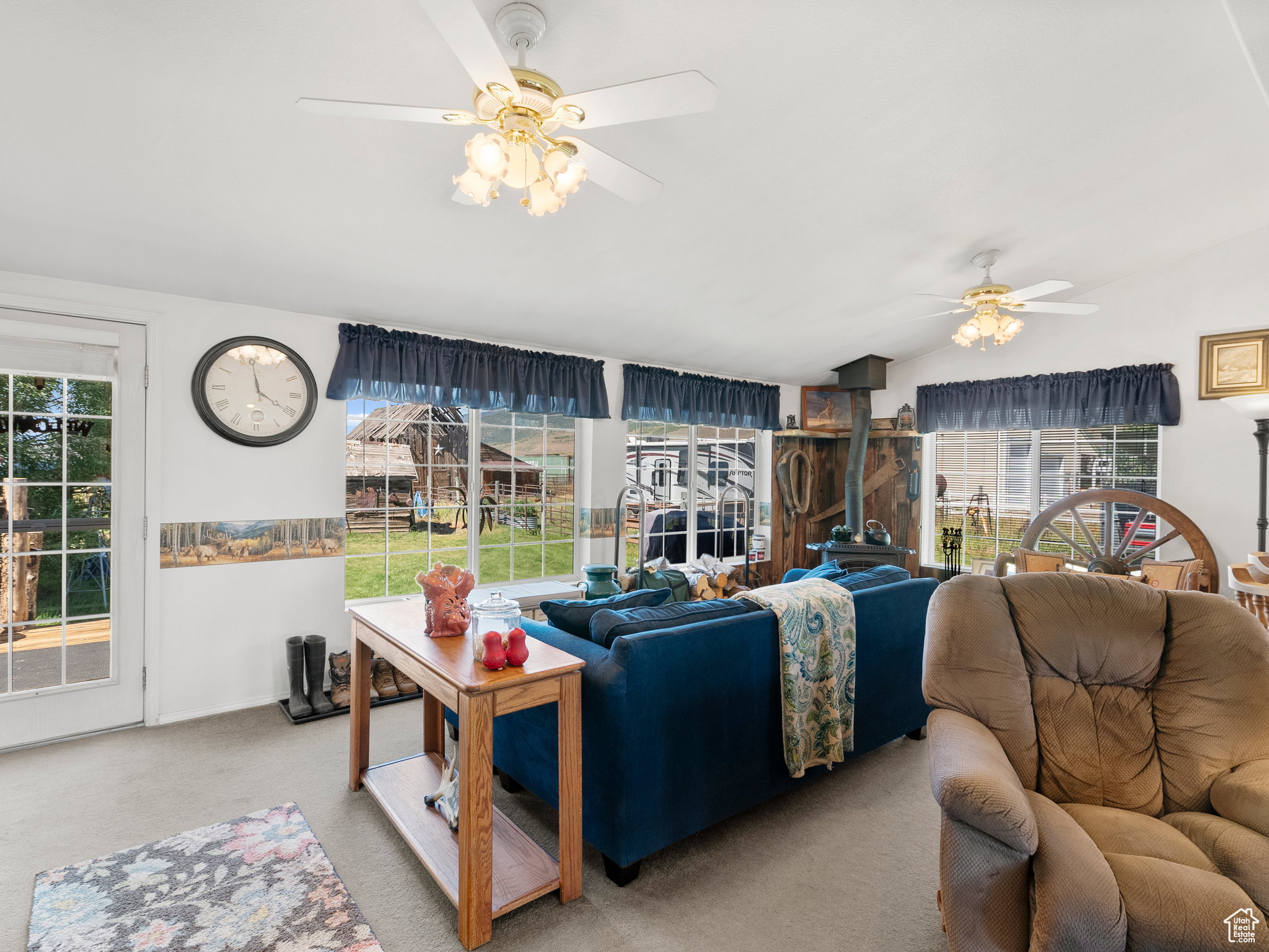 Additional living space by a wood burning stove with large picturesque windows.