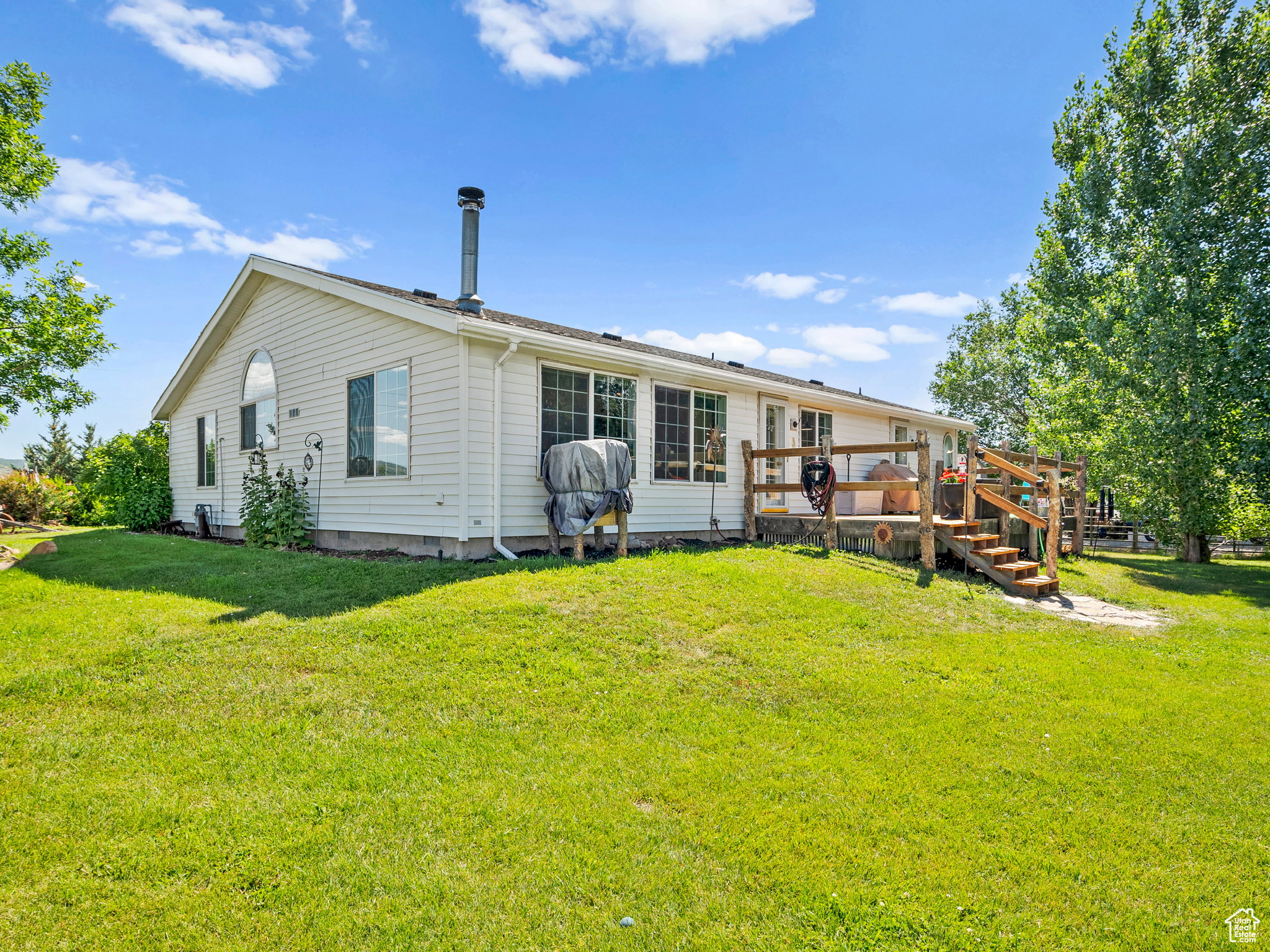 Back of the home, featuring a large wooden deck.