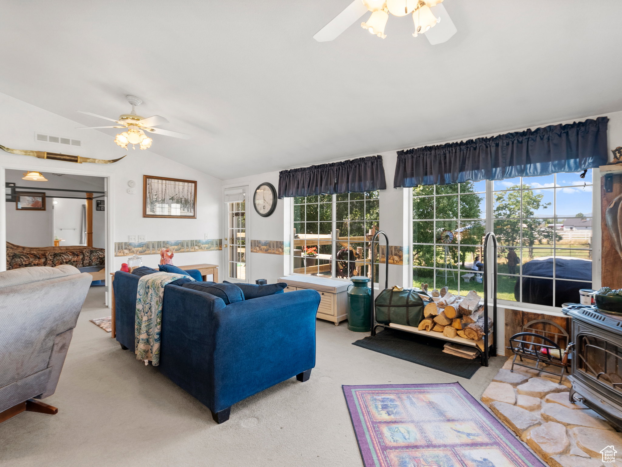 Additional living space by a wood burning stove with large picturesque windows.