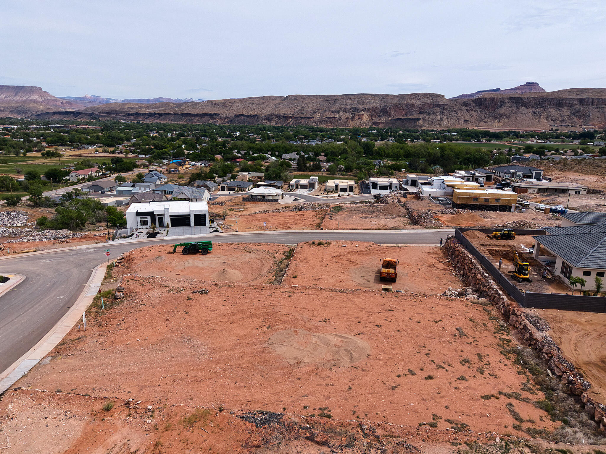 Expansive undeveloped lot featuring a red earth landscape and partial street frontage