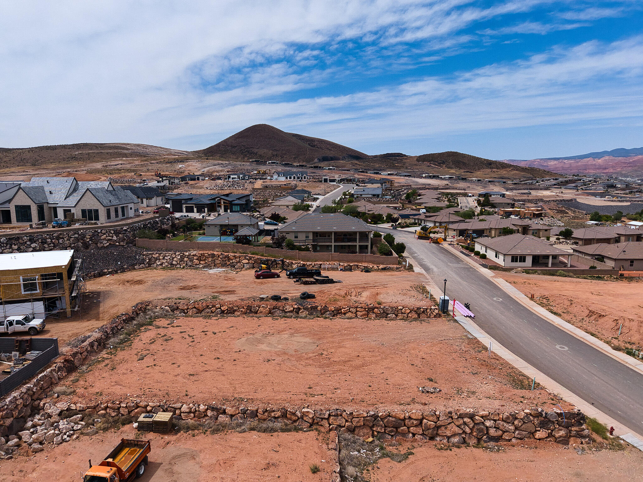 Expansive undeveloped parcel featuring rock retaining walls, flat building pads, and direct road frontage