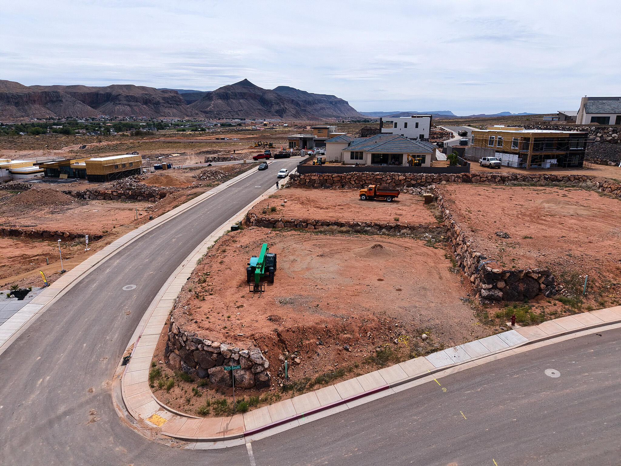Graded building lot featuring established curb, gutter, and sidewalk infrastructure