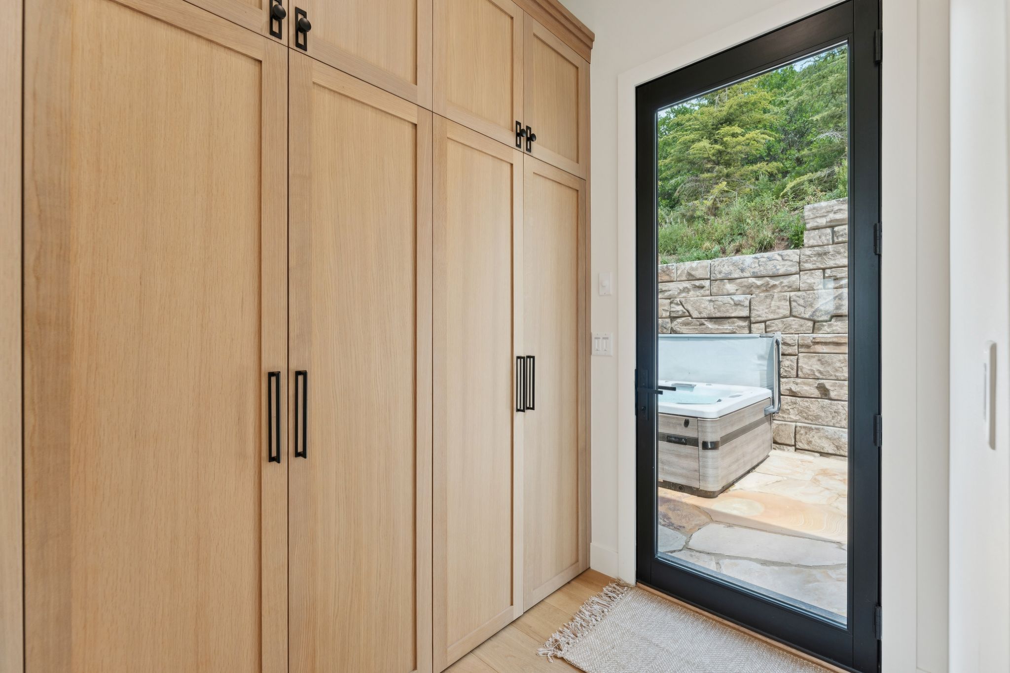 Built-in wood-finish cabinetry featuring matte black hardware