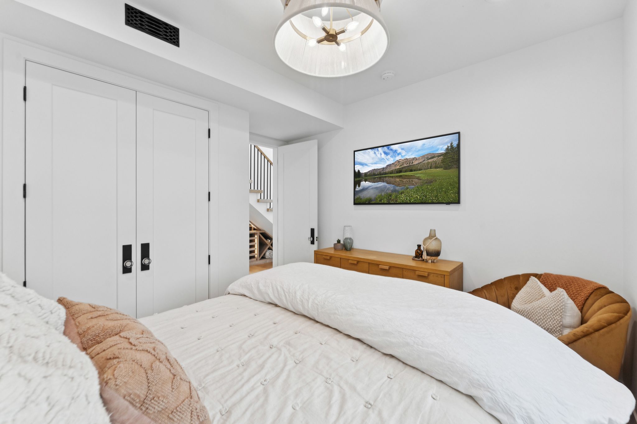 Recessed ceiling vent and a contemporary drum chandelier illuminate the space