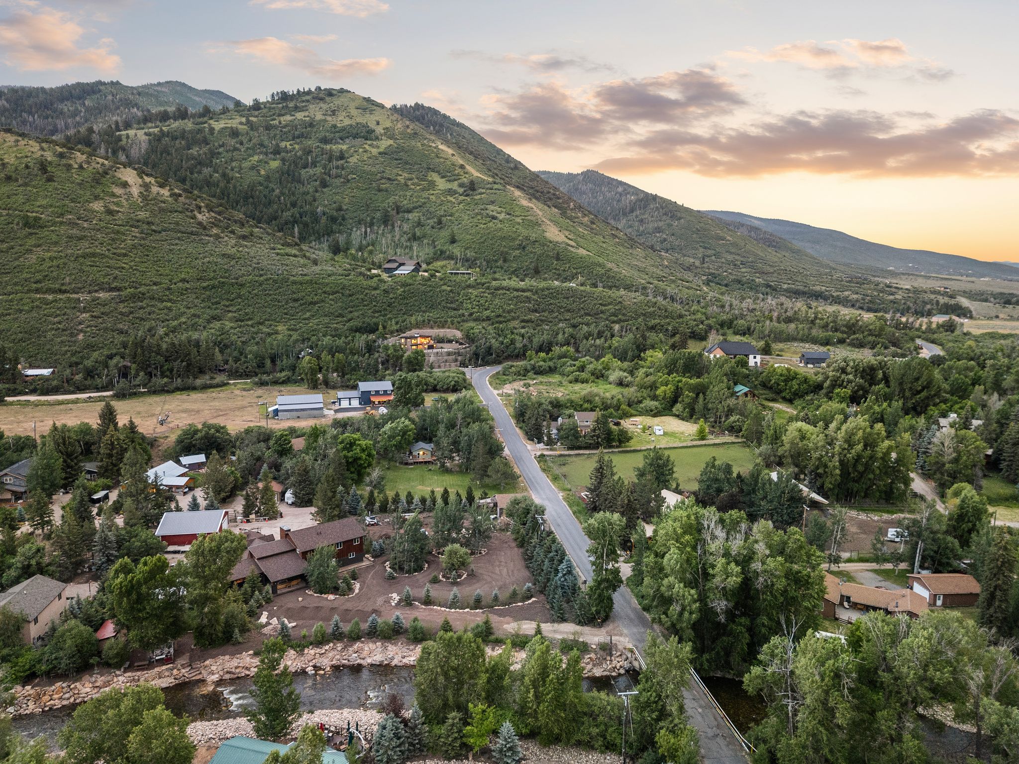 Aerial perspective showcasing verdant mountains, a winding river, and a network of roads