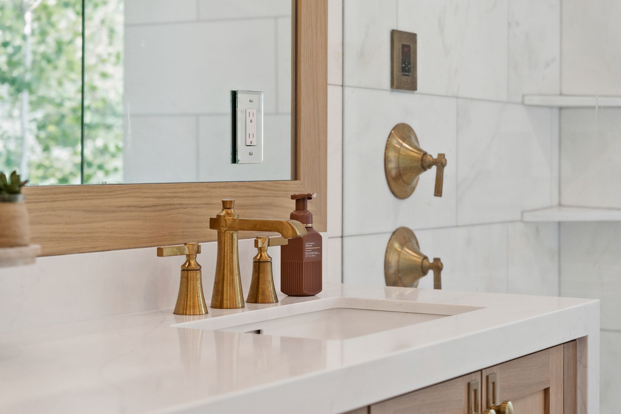 Vanity featuring a white countertop with an undermount sink and brass-finish faucet