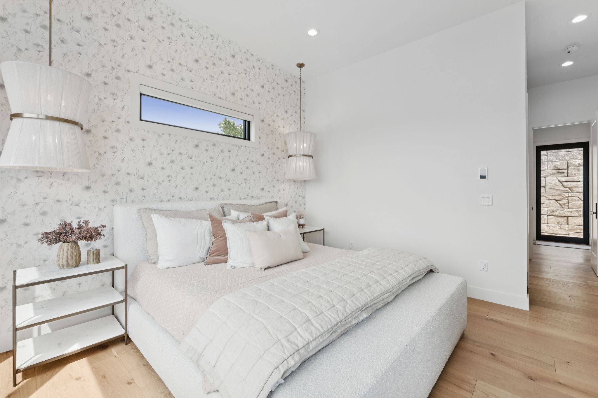 Bedroom featuring a vaulted ceiling with recessed lighting, patterned wallpaper, and light wood-finish flooring