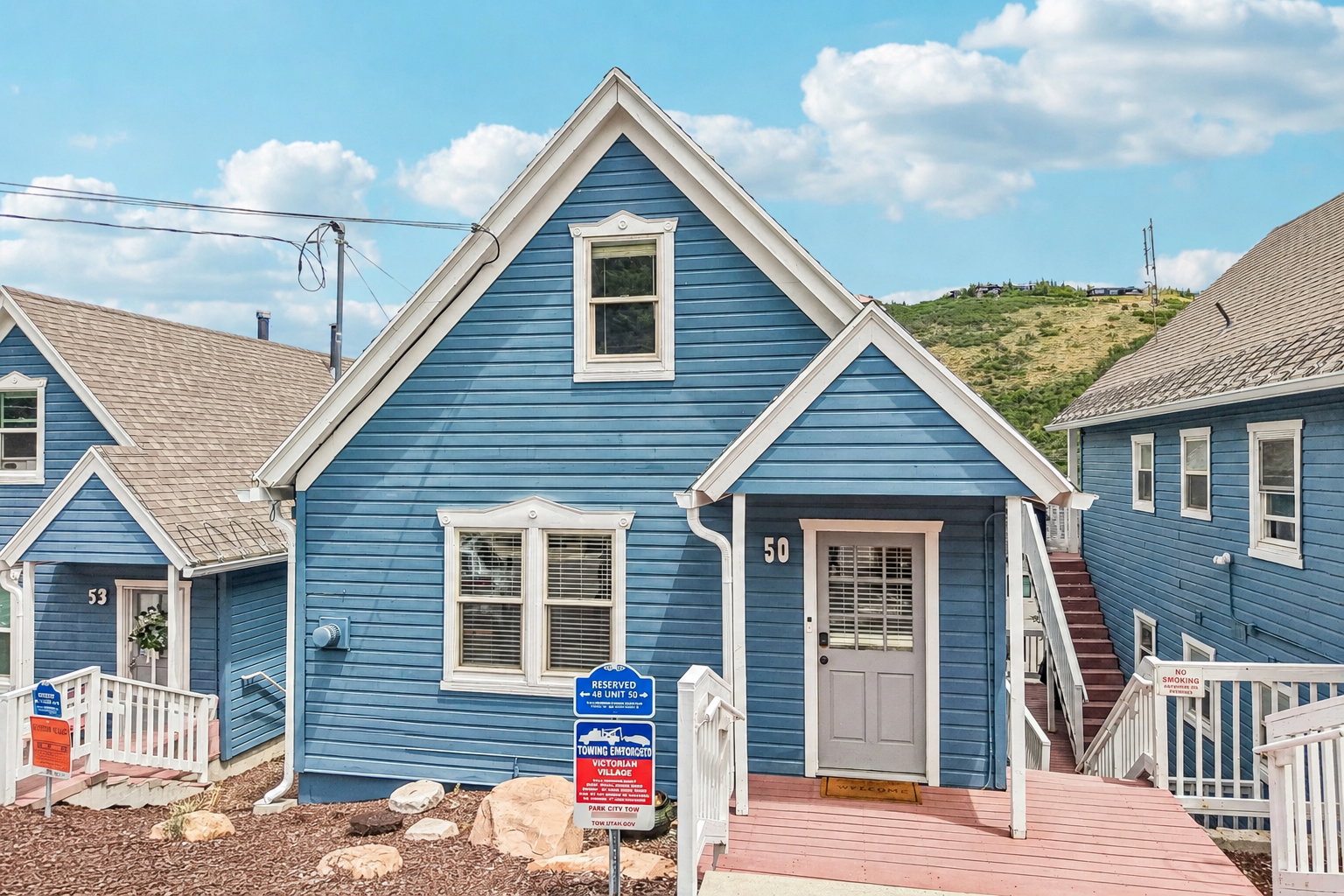 Gabled home with blue horizontal siding, white trim, and a covered front entry