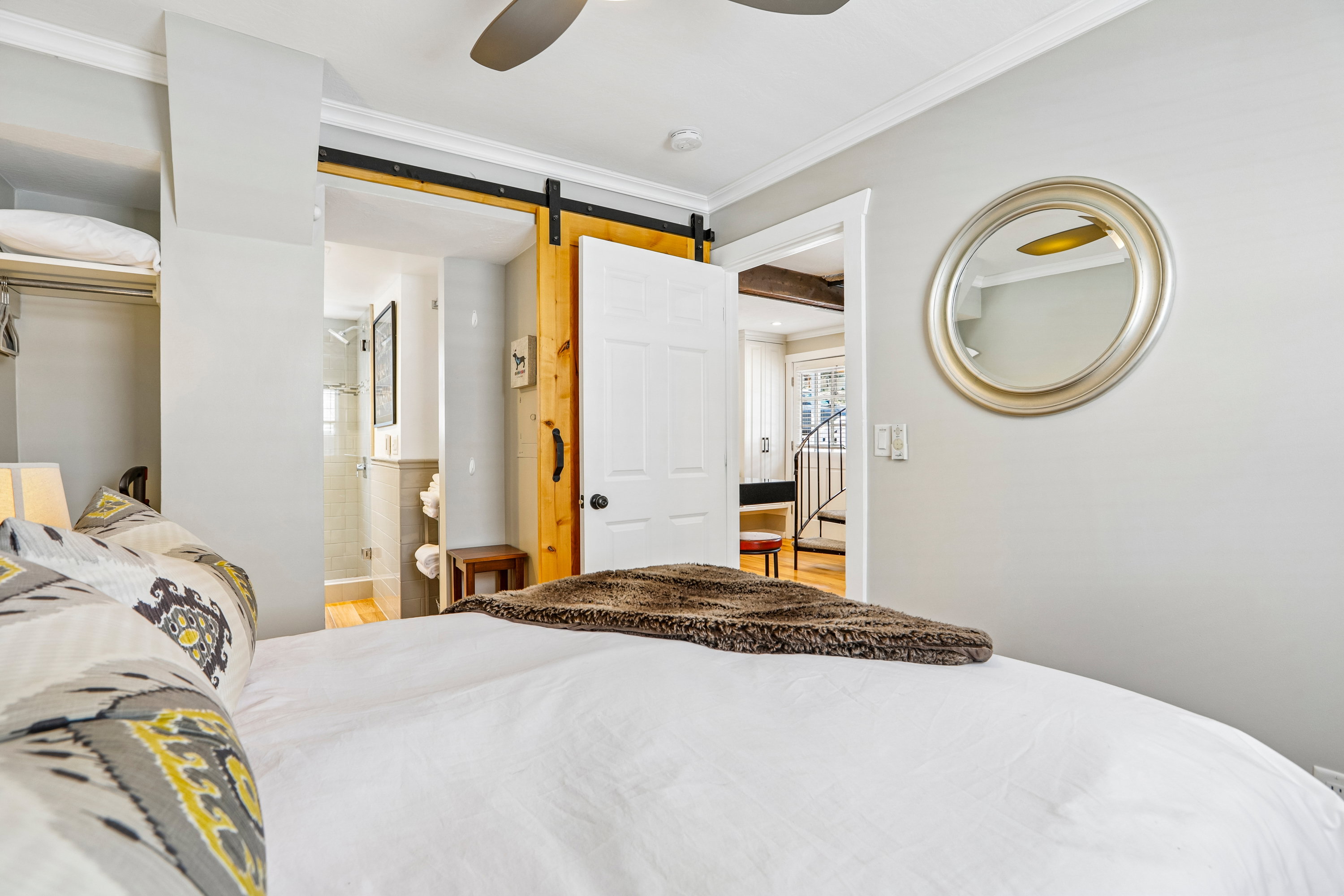 Bedroom featuring light gray walls, white crown molding, and a ceiling fan