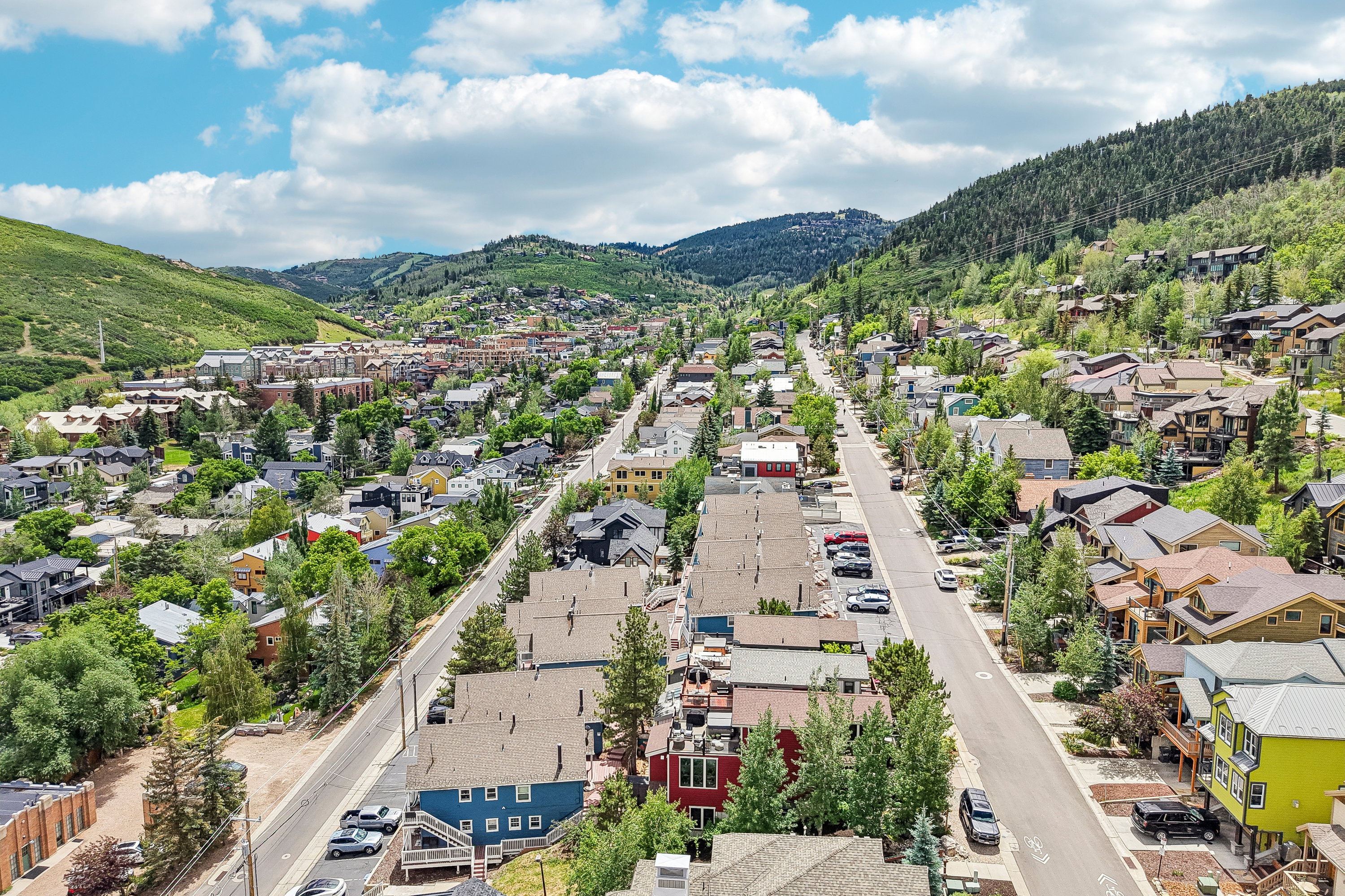 Aerial perspective showcasing a mountain town with a paved street flanked by residential properties