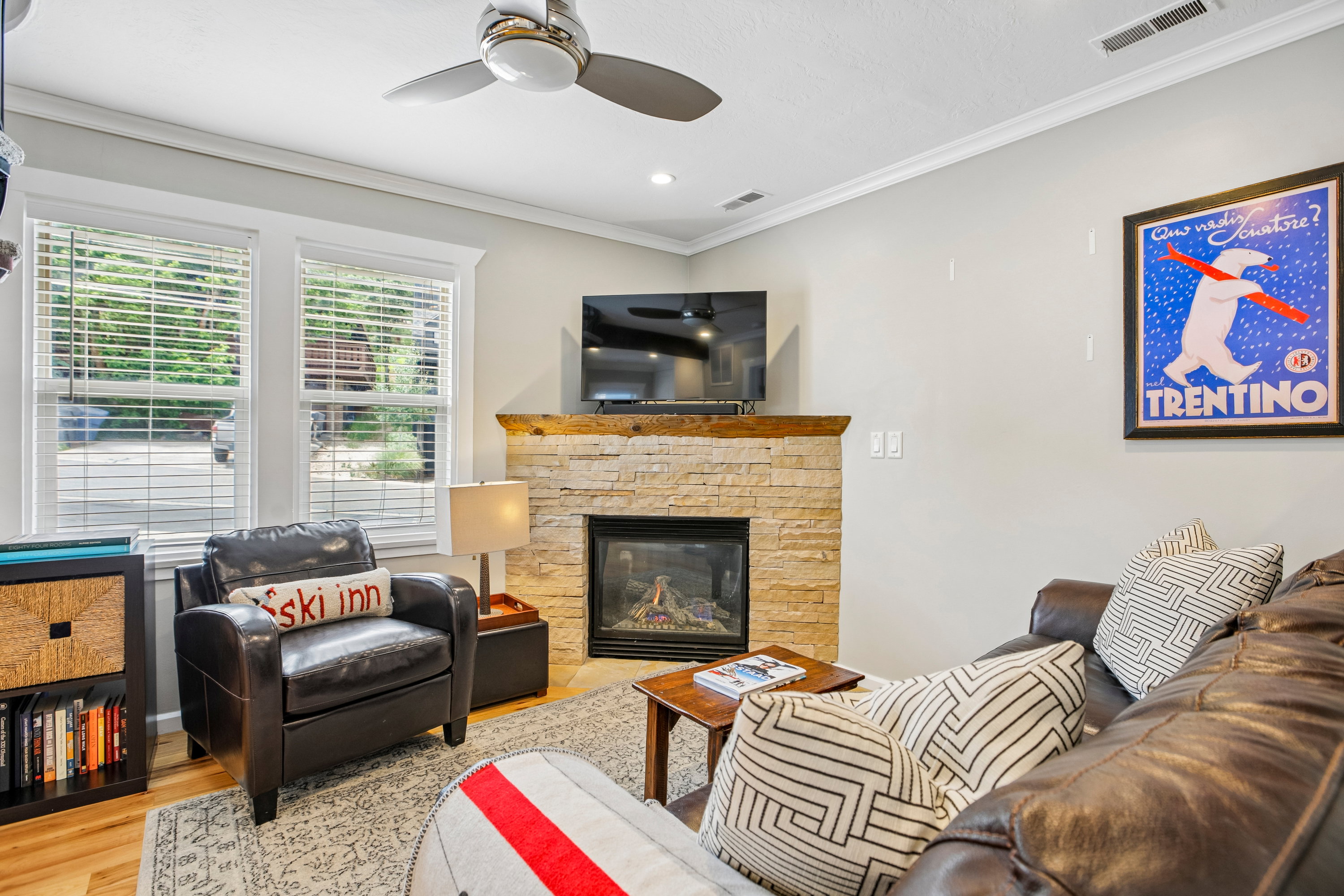 Corner gas fireplace with a stone surround and wood mantel