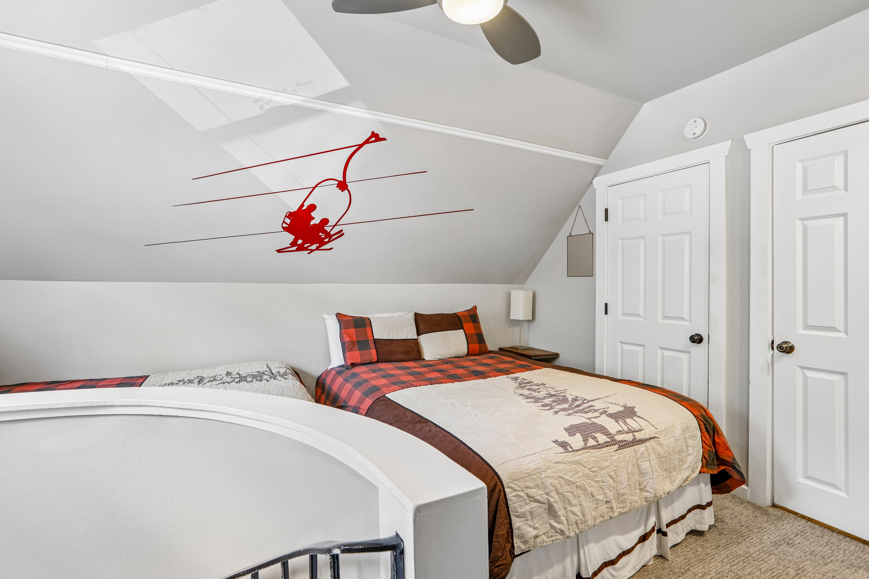 Sloped ceiling room featuring a ceiling fan, light gray wall paint, and white trim