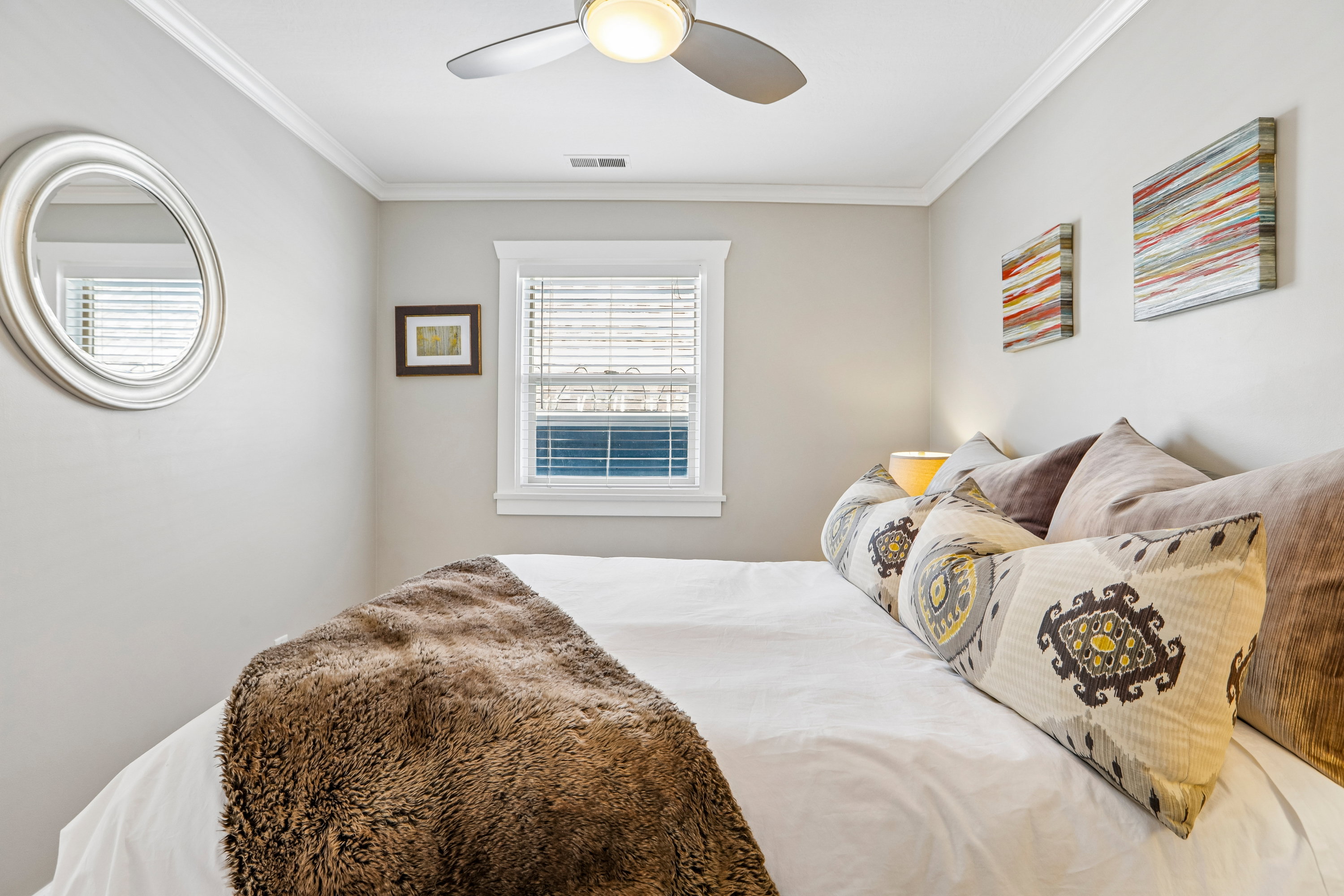 Neutral wall paint, crown molding, and a ceiling fan with integrated lighting