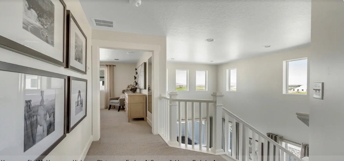 Carpeted hallway leading to a bright landing with multiple windows and white wood balusters. PICTURE IS OF A SIMILAR HOME