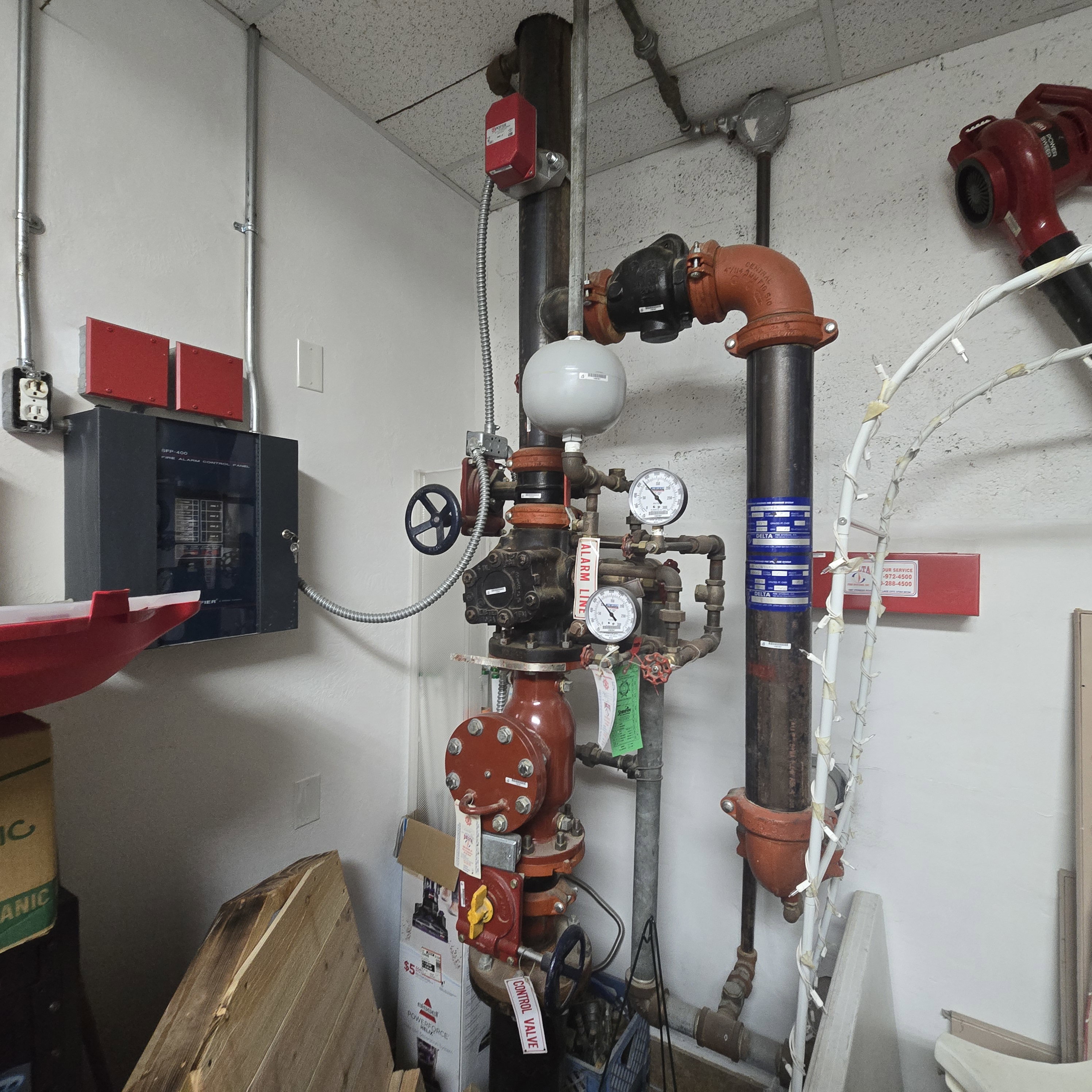 Commercial-grade sprinkler system featuring red pipes, pressure gauges, and control valves